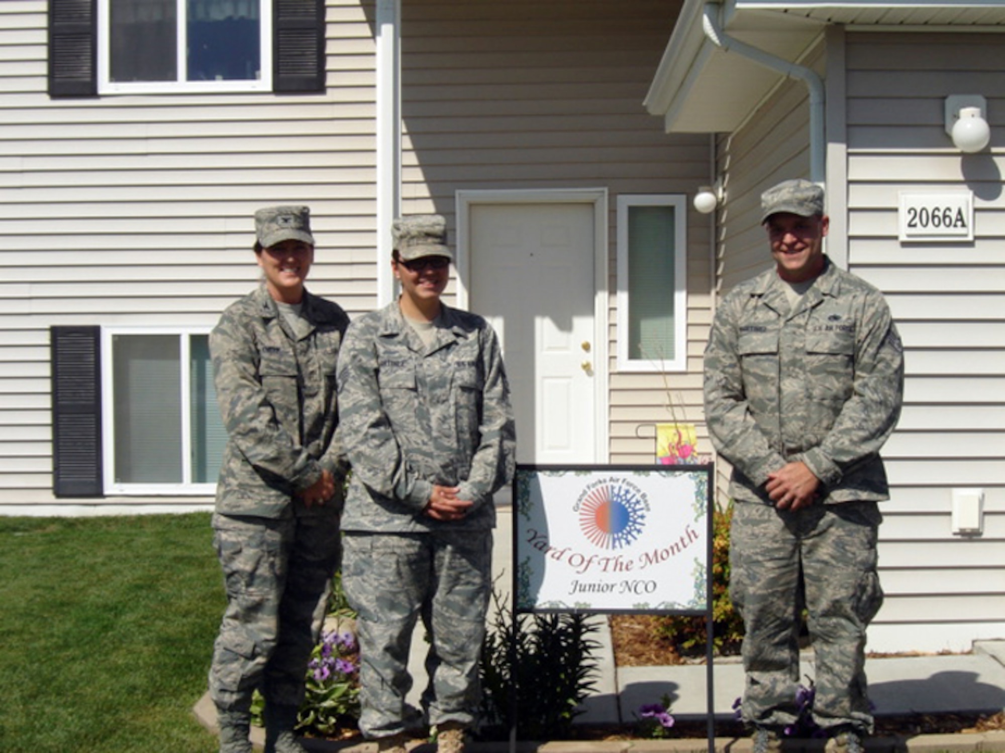 Col. Tammy Knierim, 319th Mission Support Group commander, presents Staff Sgt. Jeremy Martinez, 373rd Training Squadron Detachment 10, and Caroline Martinez, 319th Operations Group, with the July 2010 Yard of the Month, Junior NCO Category. The yard of the month program recognizes the hard work and effort of base residents that exceed the yard maintenance standards. (Courtesy photo)