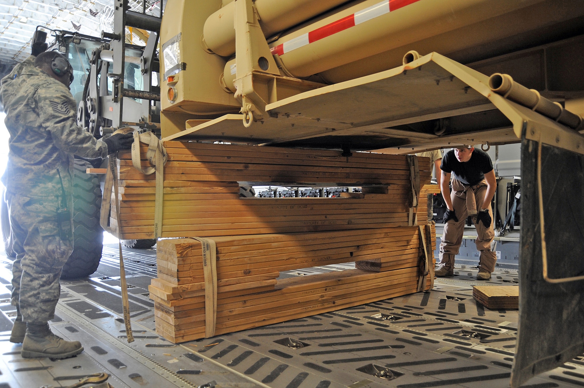 Tech. Sgt. Joseph Munn directs the placement of wooden beams to secure a 25-foot bulk helium trailer as part of a helium loading mission Aug. 24, 2010 at a non-disclosed base in Southwest Asia. Sergeant Munn is the non-commissioned officer in charge of the Air Terminal Operations Center with the 380th Expeditionary Logistics Readiness Squadron. The 380th ELRS delivers approximately 90,000 pounds of helium per week to the area of responsibility. (U.S. Air Force Photo/Tech. Sgt. April Wickes)