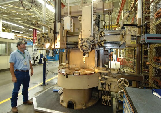 A King vertical turret lathe was installed in the industrial area of Bldg. 3001 in 1966. Work leader Kevin Greeson of the 548th Propulsion Maintenance Squadron, looks at the machine, one of several from the 60s and earlier that still work for the Air Force, often beside newer, highly computerized machines. (Air Force photo by Margo Wright)
