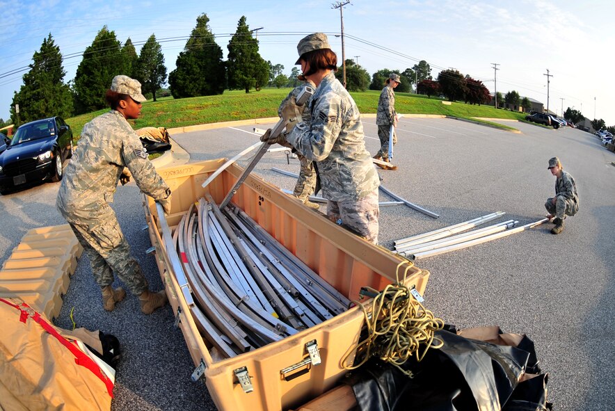 100827-F-8430J-046SHAW AIR FORCE BASE, S.C. - Staff Sgt. Natalie Tirado (left) and Senior Airman Rachel Skidmore (center), 20th Force Support Squadron personnel contingency operations, unpack material for a tent that is being constructed in front of the Chandler Deployment Processing Center Aug. 27, 2010. Members of the 20th Fighter Wing prepare for Phase I Exercise Sea Lion 10-07 by practicing how to prepare for deployments and base attacks. Shaw performs routine exercises throughout the year to ensure Airmen are ready for deployment or attacks. (U.S. Air Force photo/Airman 1st Class Amber E. N. Jacobs (Released))