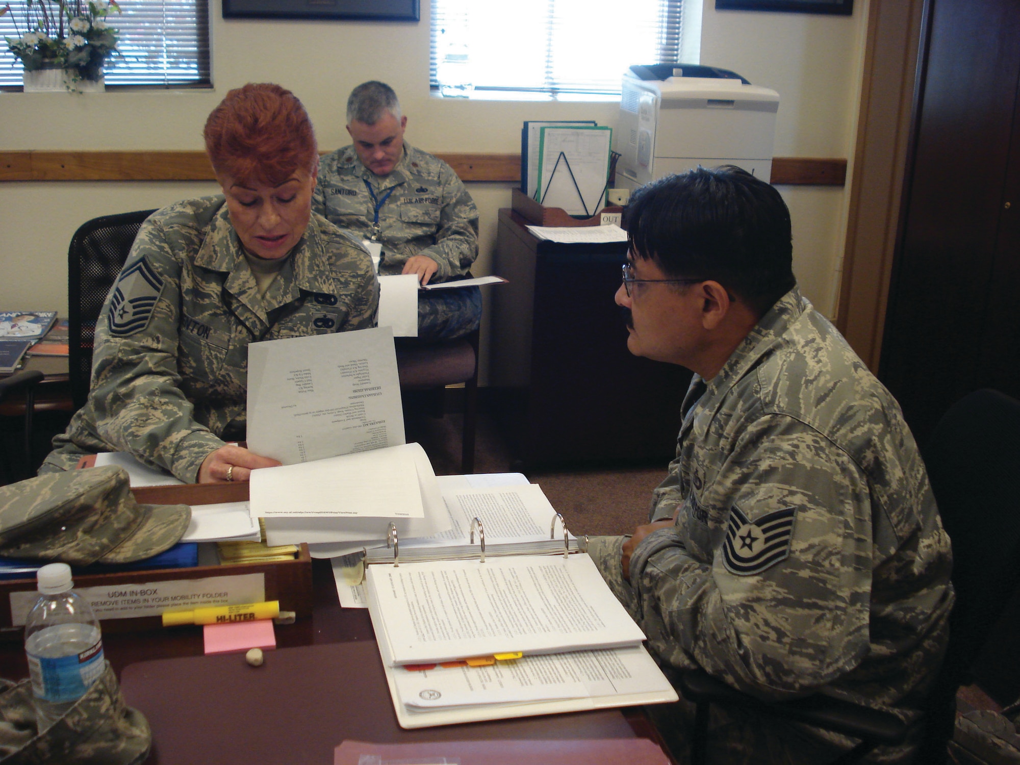 LCAP inspector Senior Master Sgt. Dwana Benton (left) and UCI inspector Maj. Gary Santoro (back) scrutinize 452nd Air Mobility Wing staff member Tech. Sgt. Angel Medoza’s unit deployment manager continuity binder at the wing headquarters building Aug. 21, 2010. (U.S. Air Force photo/Staff Sgt. Megan Crusher)                            