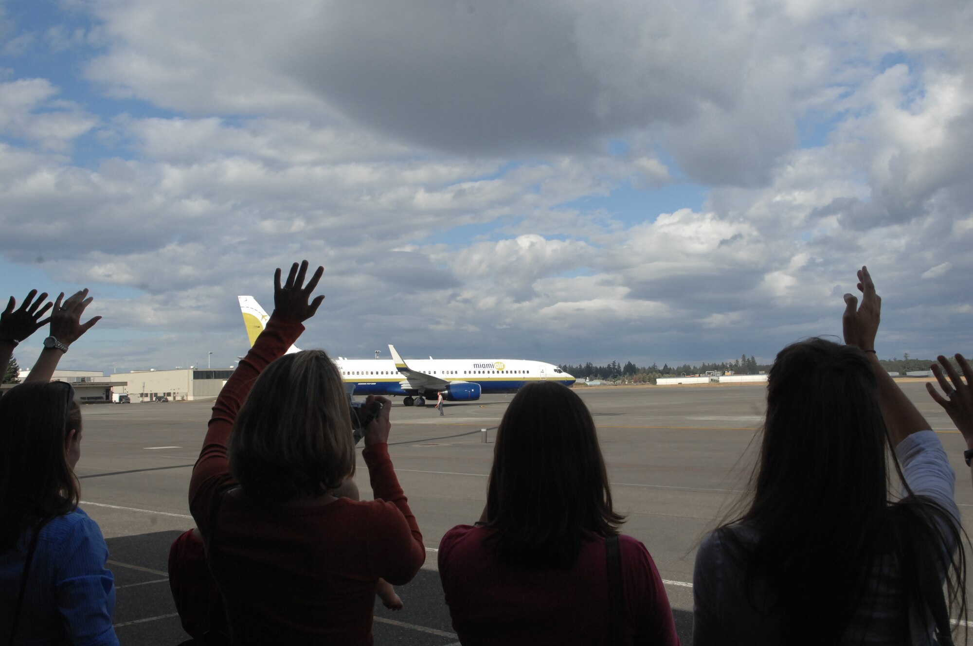 Family members wave goodbye to Airmen from the 4th Airlift Squadron as they leave for a four-month deployment. The 4th AS will be replacing the 8th AS, which comes home the first week of September.(U.S. Air Force Photo/Airman Leah Young)