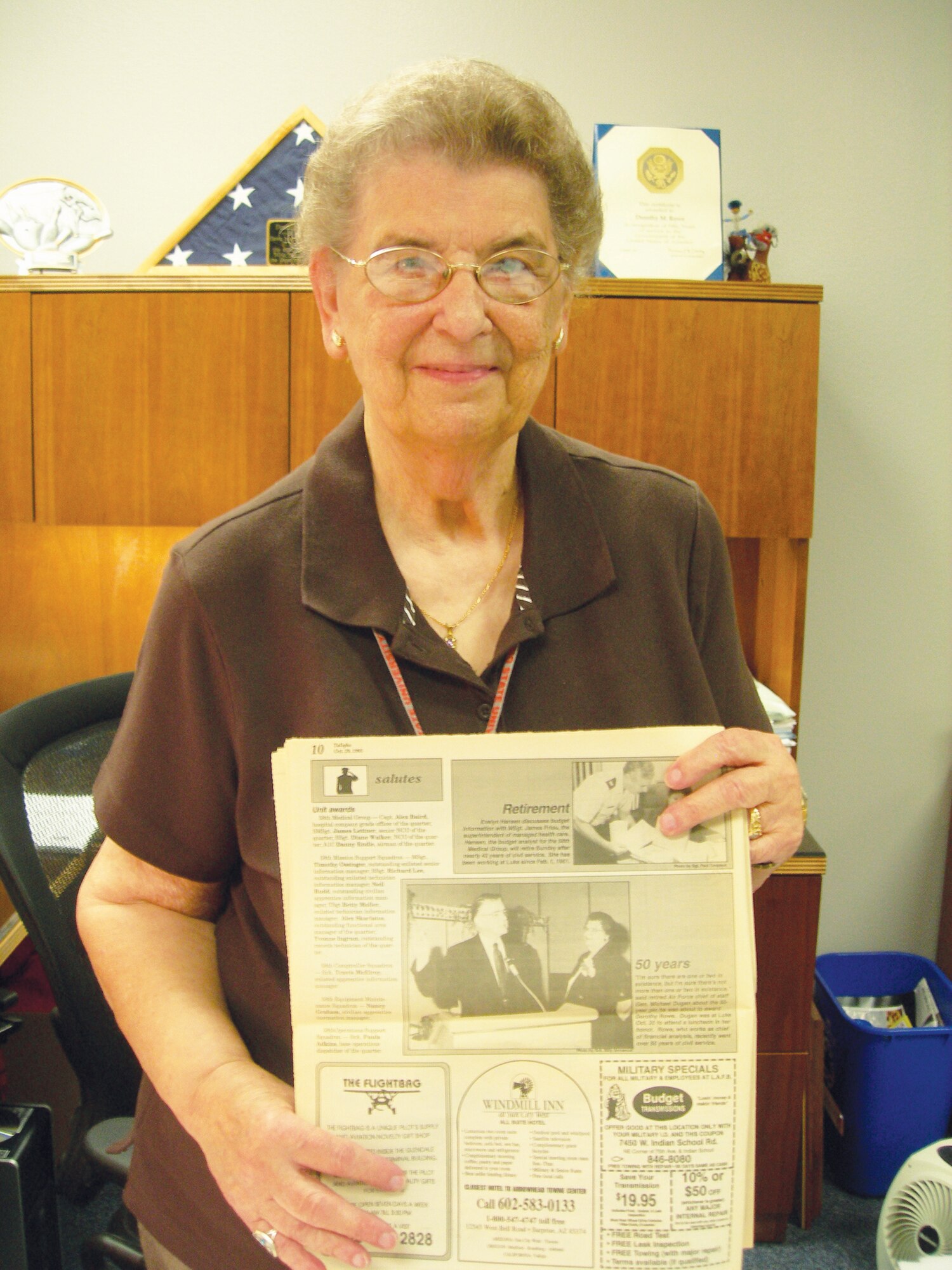 Dorothy Rowe, 56th Comptroller Squadron financial analysis chief, holds a photo of her 50th Anniversary luncheon in the October 9, 1993 edition o fthe Luke Air Force Base newspaper, then called the Tallyho.  She has been working at Luke Air Force Base for 53 years with a total of almost 67 years of service.  (U.S. Air Force photo\Airman 1st Class Melanie Holochwost)