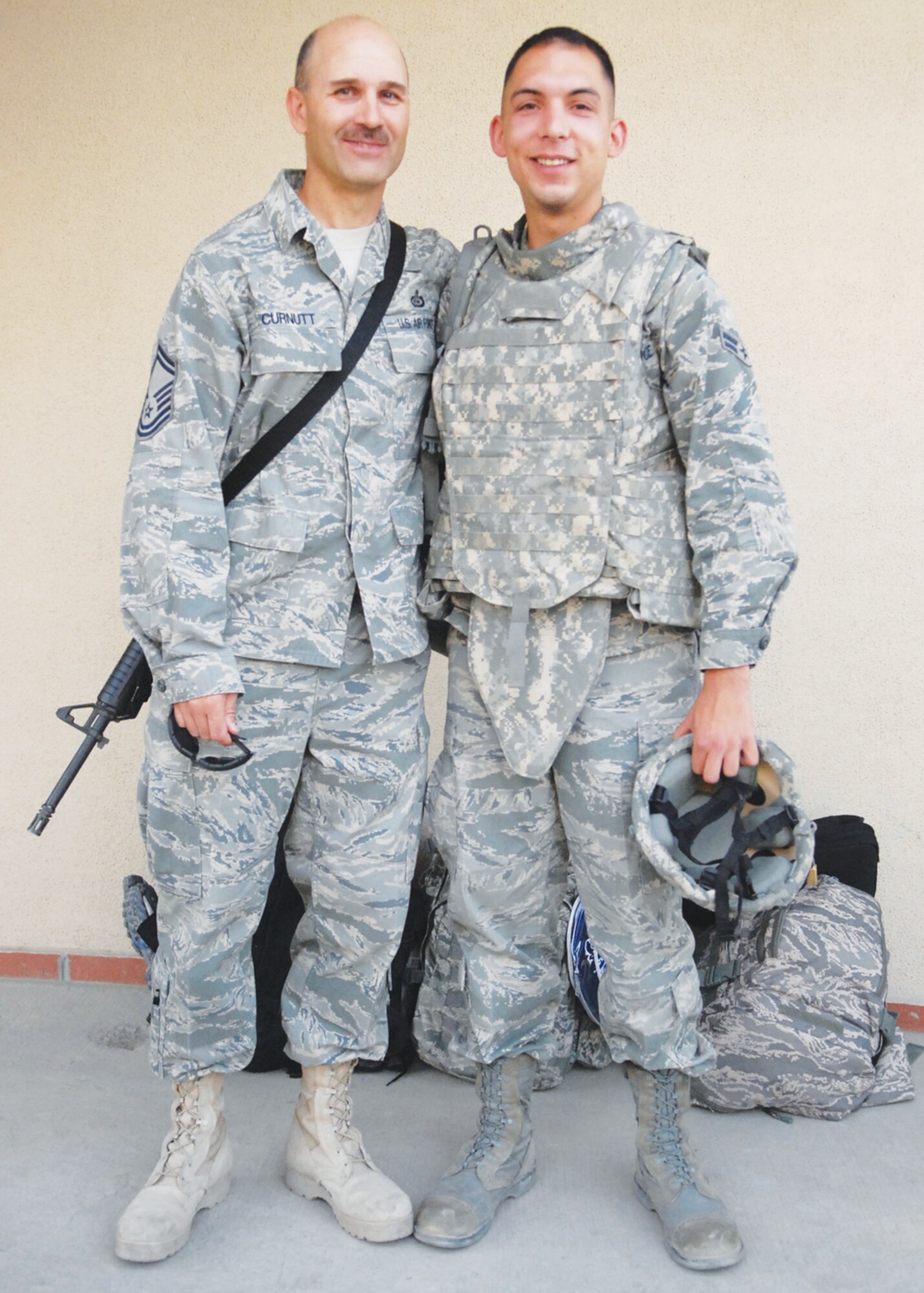 Senior Master Sgt. George Curnutt, J-2 NCO-in-charge, poses with his son, Airman 1st Class Shane Curnutt, 56th Communications Squadron, after welcoming the younger Curnutt to Afghanistan.  While the senior Curnutt will be leaving soon, the younger Curnutt is just starting a deployment to International Security Assistance Force.  (U.S. Air Force photo/Senior Airman William A. O'Brien)