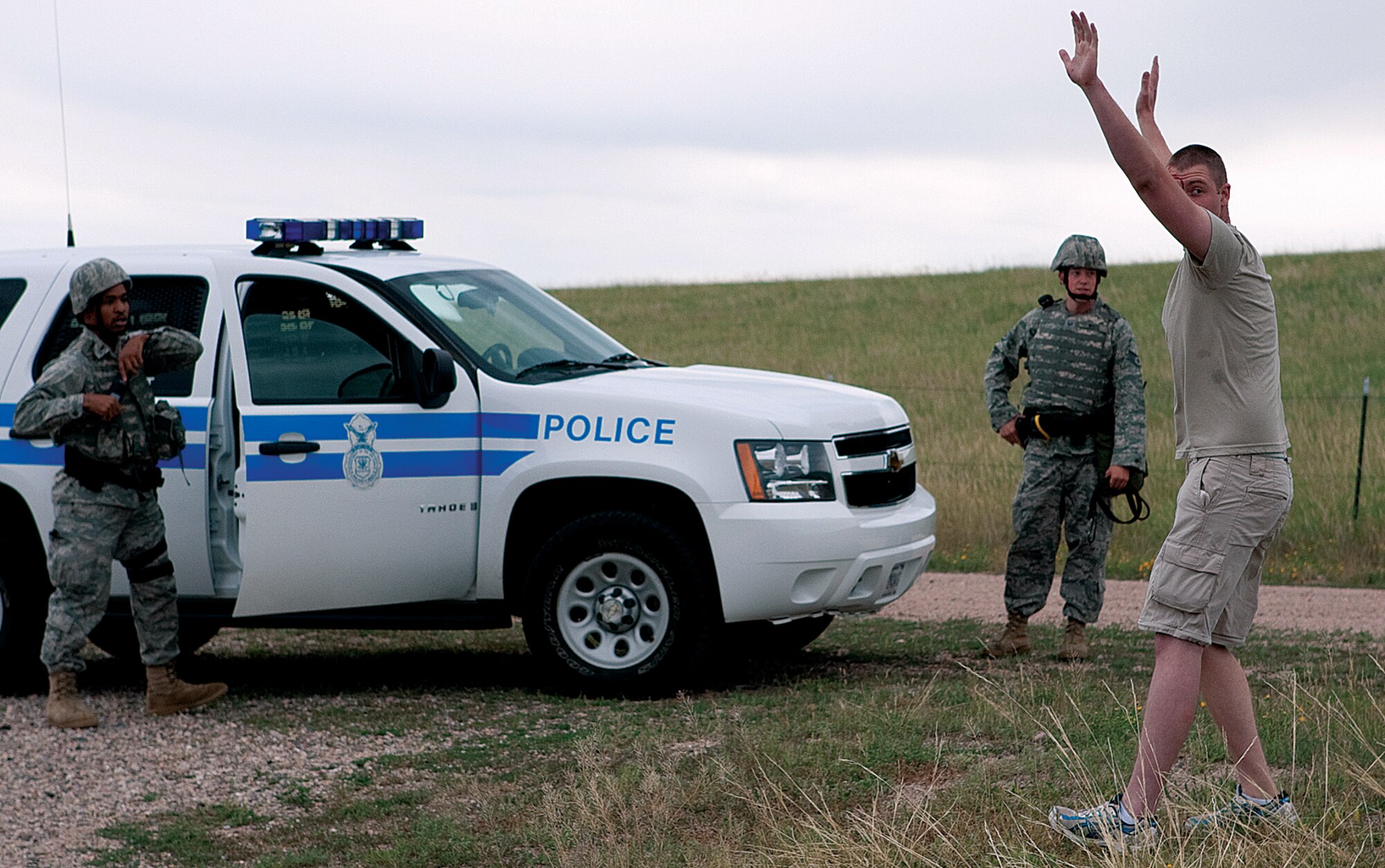 First Lt. Kenneth Canty and Staff Sgt. Nicholas White, both from the 90th Security Forces Squadron, stop a victim from running toward them, which allowed them to take control of the scene during the base exercise Aug. 19. (U.S. Air Force photo by Jeff Allred)