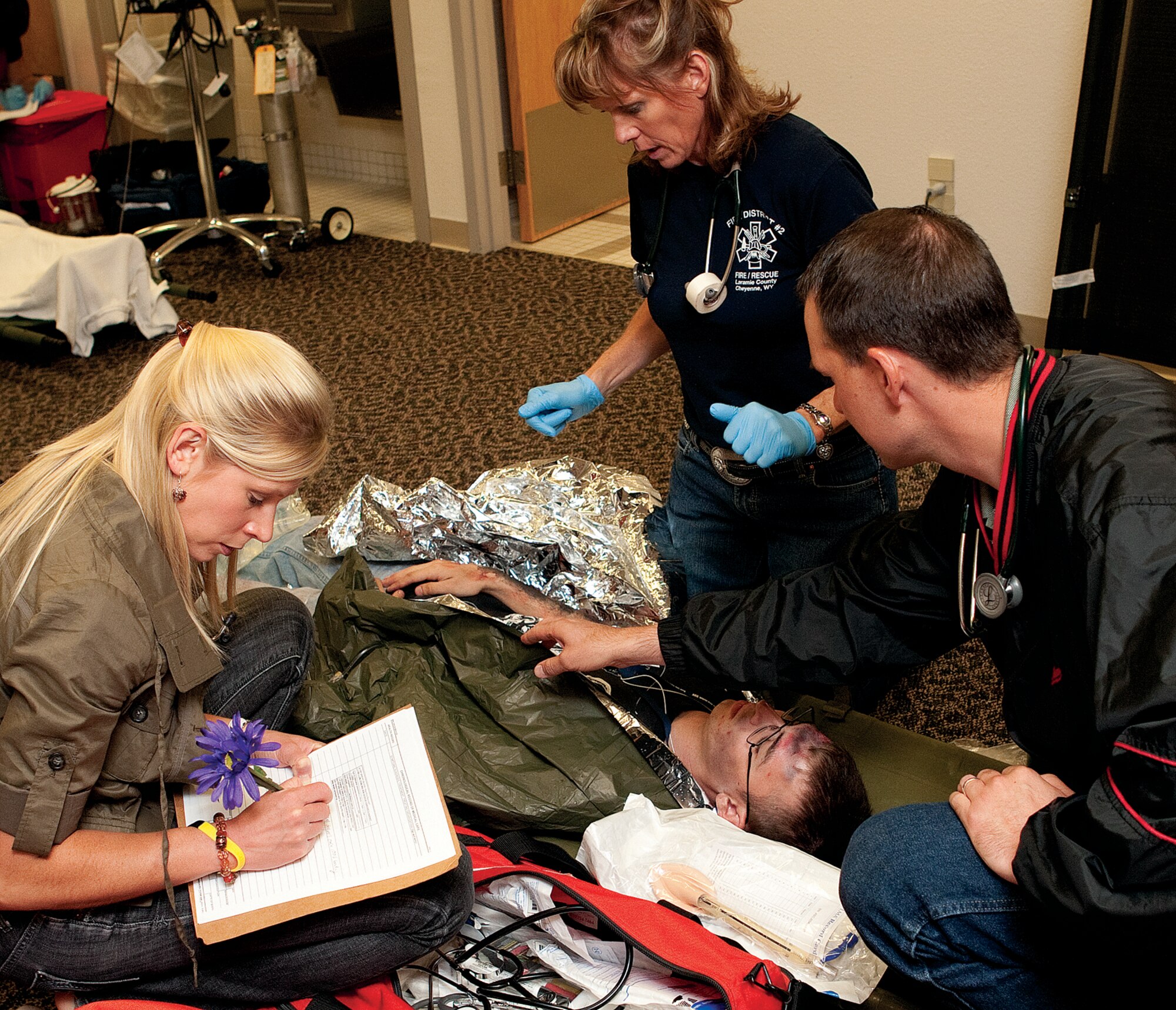 Members of the 90th Medical Group staff and Fire District 2 evaluate triaged patients as they arrive to the clinic during the base exercise Aug. 19. (U.S. Air Force photo by Jeff Allred)