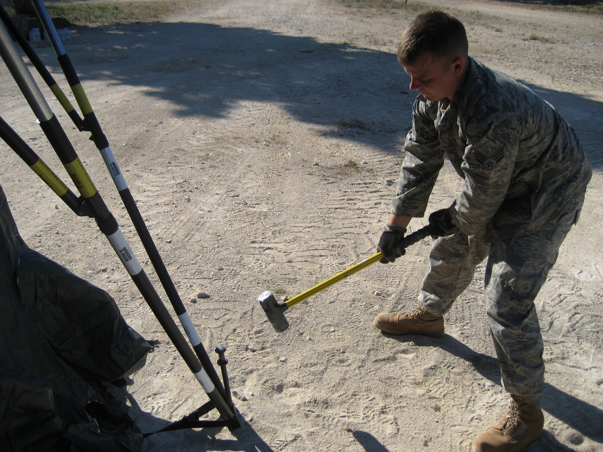 Senior Airman Ben Rasine, 1st Special Operations Civil Engineer Squadron J-Team, hammers a stake to secure a tent during Operation Jackal Stone in Croatia, September 2009. The J-Team is comprised of engineering specialists who enable special operations forces by providing resources to sustain their presence for weeks wherever they are required. (Courtesy photo from U.S. Air Force 1st Lt. Jeffrey Buchholtz)