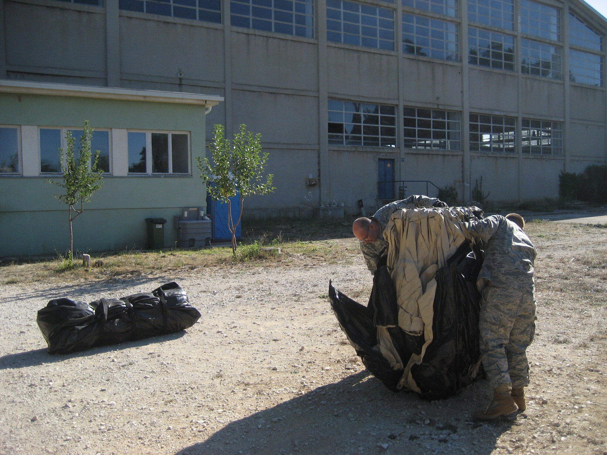 Master Sgt. James Jarvis, left, and Senior Airman Ben Rasine, right, both 1st Special Operations Civil Engineer Squadron J-Team, open a tent segment of an air rapid response kit during Operation Jackal Stone in Croatia, September 2009. The J-Team is comprised of engineering specialists who enable special operations forces by providing resources to sustain their presence for weeks wherever they are required. (Courtesy photo from U.S. Air Force 1st Lt. Jeffrey Buchholtz)
