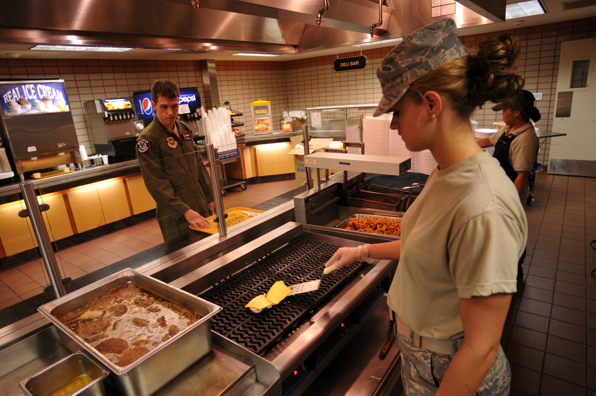 Airman 1st Class Caitlin Taylor, 115th Force Support Squadron, prepares a cheeseburger for a waiting patron at the dining facility at Eielson AFB, Alaska Aug. 18. Taylor deployed to Eielson in support of the 115th Fighter Wing out of Madison, Wis. (Wisconsin Air National Guard photo by Tech Sgt. Ashley Bell)