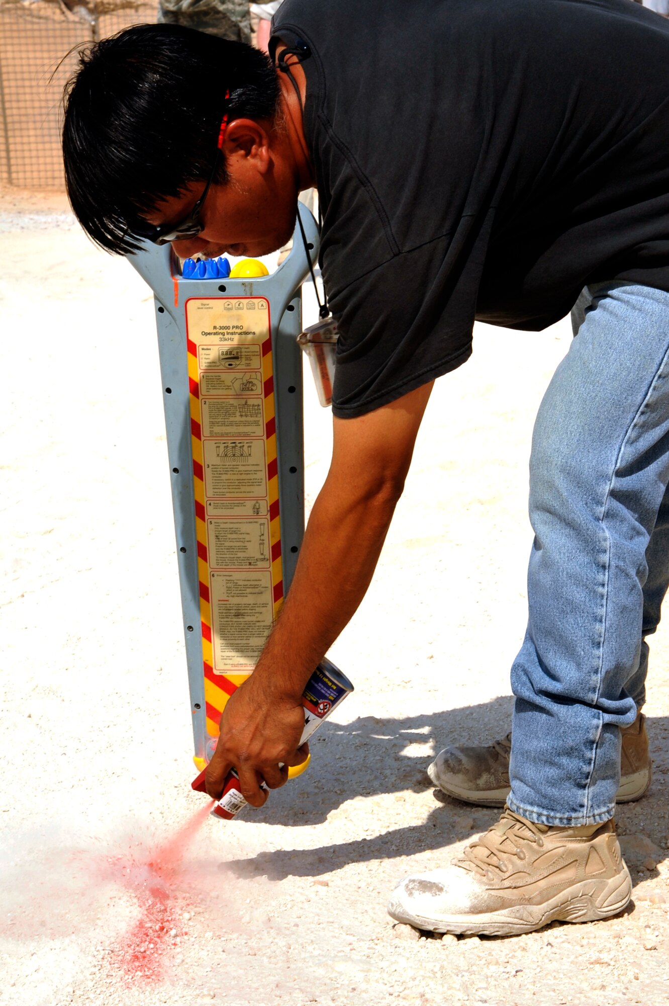 A contractor uses paint to mark the location of an electrical cable using a magnetic field cable locator Aug. 17, 2010 at Al Asad Air Base, Iraq. Contractors and Air Force engineers are plotting the location of power lines, to be added to the base map as the U.S. can provide detailed maps of the base for when the U.S. military returns the base to the Iraqis. (U.S. Air Force photo by Senior Airman Perry Aston) (Released)