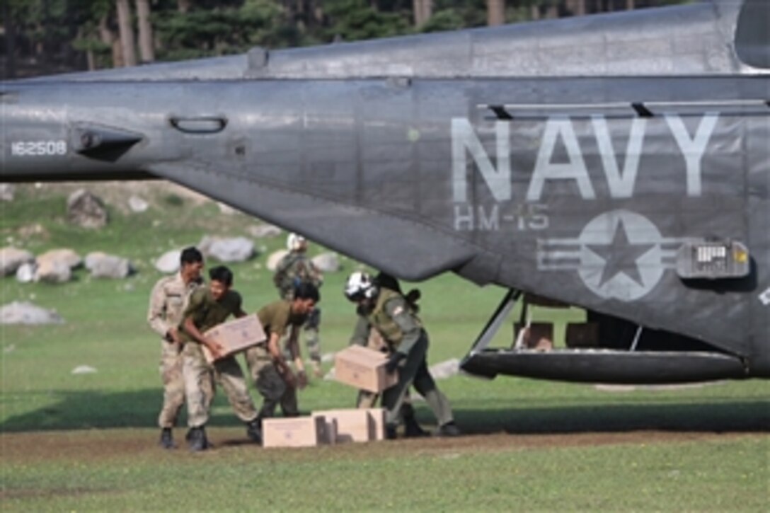U.S. Navy sailors with Helicopter Mine Countermeasures Squadron 15, Detachment 2 help Pakistani soldiers offload relief supplies from a U.S. Navy MH-53E Sea Dragon helicopter during humanitarian relief efforts in Khyber-Pakhtunkhwa province, Pakistan, on Aug. 21, 2010.  