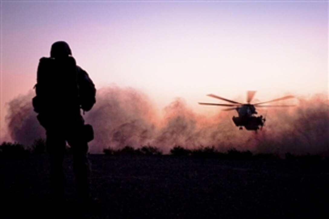 U.S. Navy Petty Officer 3rd Class Tyrel Greenough watches the helicopter that will take him and the rest of the men participating in Operation Big Wave back to base land in Khanagawr, Afghanistan, Aug. 20, 2010. The operation was conducted to disrupt the enemy from using supply lines to bring weapons and fighters into Nawa province. Greenough is a corpsman with Headquarters Company, 3rd Battalion, 3rd Marine Regiment.