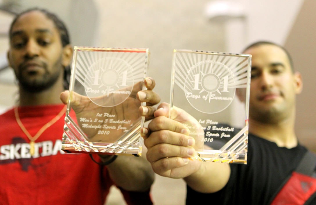 Daniel Phair (left), assistant coach and personal trainer, Paige Fieldhouse gym, and Sgt. Ariel Garcia, administrative clerk, Marine Medium Helicopter Training Squadron 164, Marine Aircraft Group 39, hold their first place trophies for men’s 3-on-3 basketball at Camp Pendleton’s Paige Fieldhouse during the 2010 Sport’s Jam event that concluded Marine Corps Community Service’s 101 Days of Summer campaign, Aug. 27. More than 200 service members participated in the event that promoted a Drug-Free Challenge sponsored by the Single Marine Program and Semper Fit Health Promotions. The Sports Jam included men and women teams for 3-on-3 basketball, singles racquetball, singles table tennis, co-ed teams for 5-person dodge ball and 4-person volleyball.