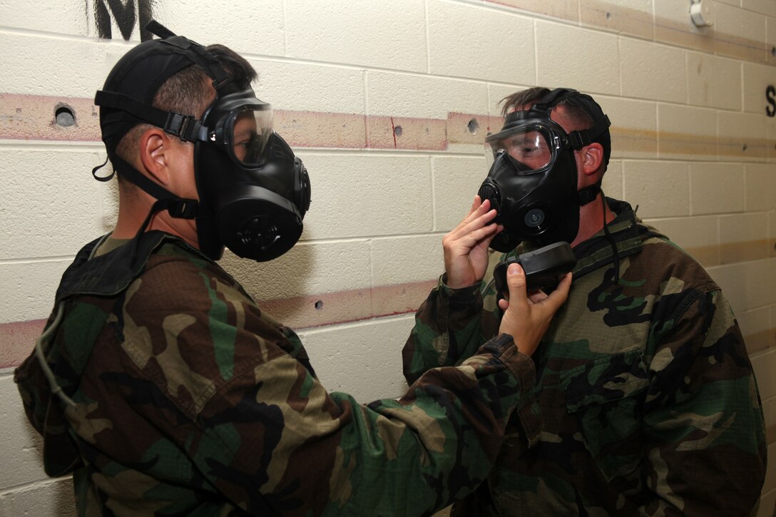 Major Sean P. Smith, left, 22nd Marine Expeditionary Unit’s logistics officer and Franklin Park, N.J., native, removes a filter from Capt. Michael C. Waugh’s, the MEU’s supply officer and Forrest City, Iowa, native, M-50 field protective mask during the MEU’s annual gas-chamber training aboard Camp Lejeune, N.C., Aug. 27, 2010. The M-50 incorporates two filter systems to allow filter changes in an area with contaminated air. The MEU was the first major subordinate command in the Marine Corps on the east coast to receive the new M-50 gas mask for training. The training is designed to instill confidence in the mask and ensure the Marines know the proper wear of the equipment.
