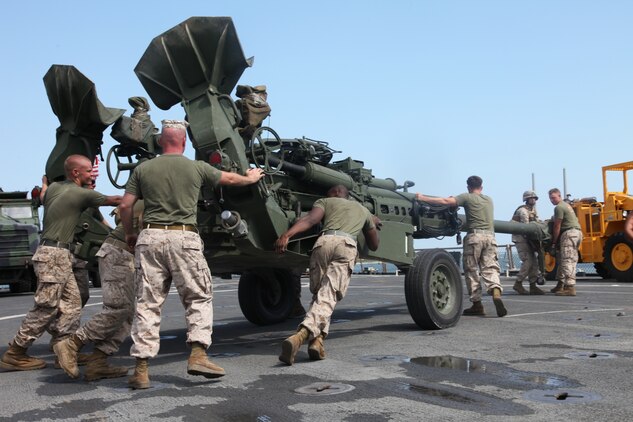 Marines with Battalion Landing Team 3/8, 26th Marine Expeditionary Unit, move a M777 Lightweight Howitzer into place on the flight deck of USS Carter Hall at the Morehead City Port, N.C., August 28, 2010. 26th Marine Expeditionary Unit deployed aboard the ships of Kearsarge Amphibious Ready Group in late August responding to an order by the Secretary of Defense to support Pakistan flood relief efforts.