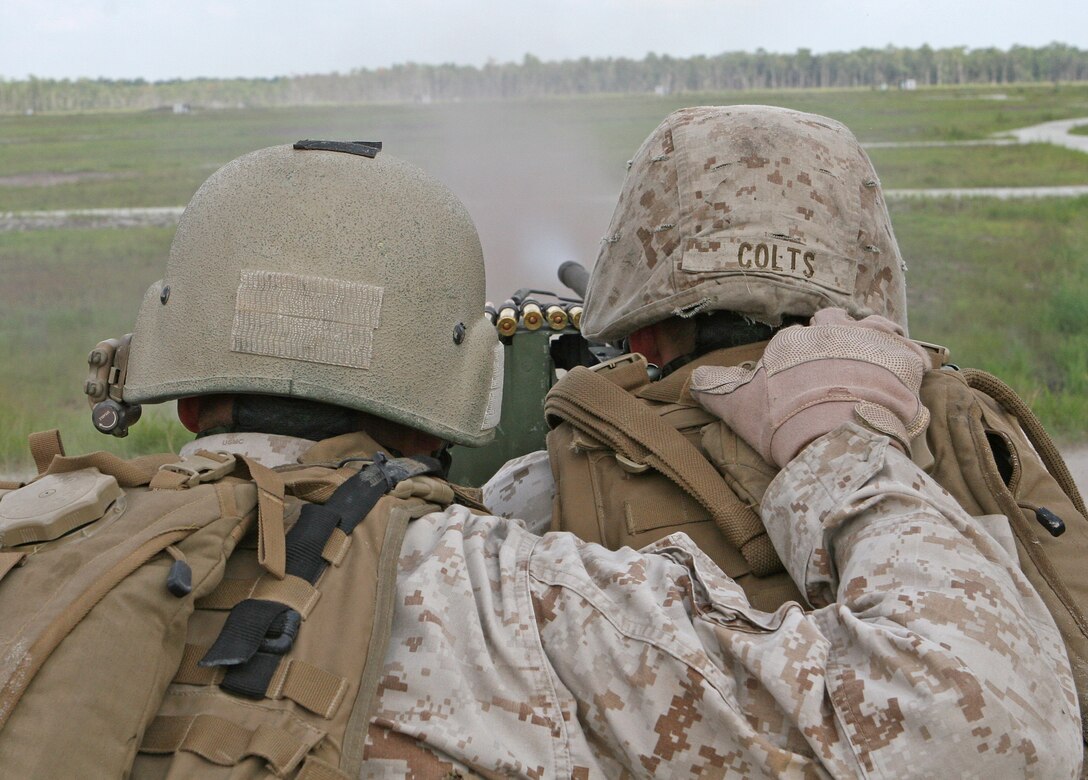 Cpl. Kenneth Doyle and Cpl. Rick Colts, both military working dog handlers with Military Working Dog Platoon, Military Police Support Company, II Marine Expeditionary Force Headquarters Group, fire an M2 .50-caliber machine gun during a field exercise aboard Marine Corps Base Camp Lejeune, N.C., Aug. 28, 2010. The exercise was designed to help the Marines of MP Support Co. sustain their proficiency with different weapons they’ll be using while deployed, as well as acclimate their military working dogs to the sounds of combat.