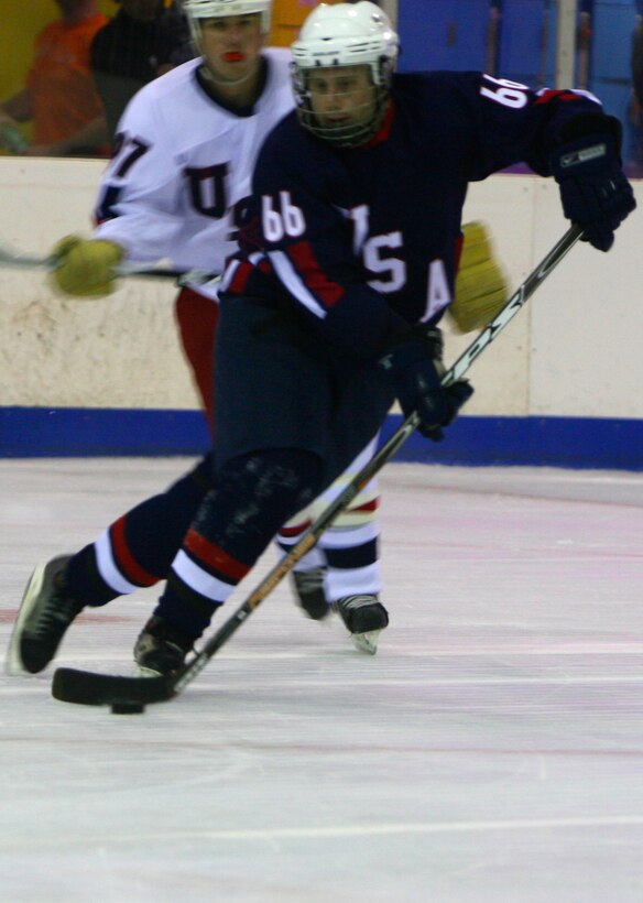 Tom Carpenter, forward for the Navy, Marine, Coast Guard team, rushes up the ice during the first-ever Wounded Warriors Charity Hockey Game Aug. 29 at the Ice Palace, Aiea, Hawaii. The Army, Air Force team took the win 5-3.