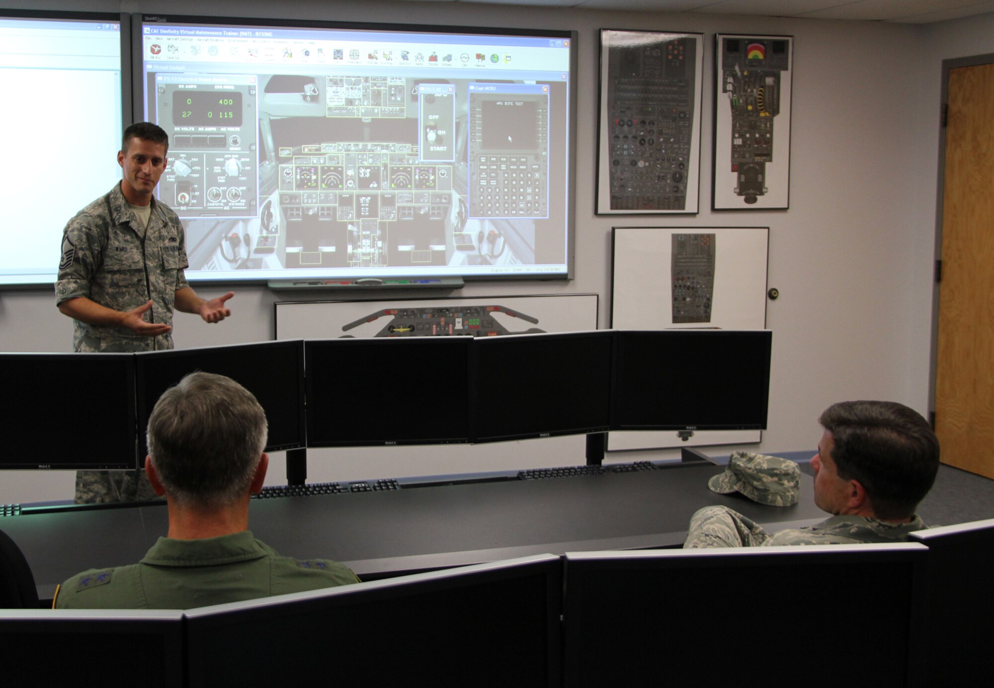 Master Sgt. Dave Ward, a maintainer with the 932nd Airlift Wing's Maintenance Group, explains to the commander of Fourth Air Force, Maj. Gen. Eric Crabtree (left), how the unit's VMT (Virtual Maintenance Trainer) works.  The touchscreen system allow a wide variety of realistic training to take place "virtually" on the screen before the maintainers of C-40C planes go out and touch the aircraft on the real flightline.  Listening in (at right) is Col. William Edwards, Jr., commander of the 932nd Airlift Wing.  (U.S. Air Force photo/Tech. Sgt. Chris Parr).