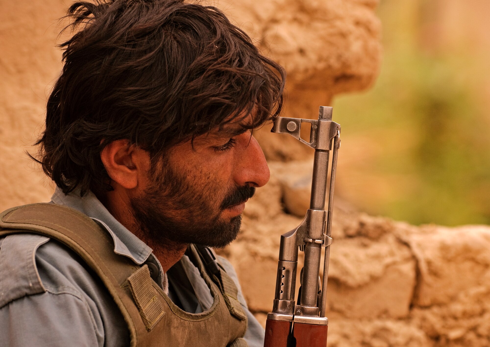 COMBAT OUTPOST MIZAN, Afghanistan - A member of the Afghan National Police takes a break while his team meets with local villagers during a dismounted patrol near Combat Outpost Mizan, Mizan District, Zabul province, Aug. 26. Members of 3rd Platoon, Fox Company, 2nd Squadron, 2nd Stryker Cavalry Regiment, Provincial Reconstruction Team Zabul and Afghan National Security Forces patrolled the area to meet with local elders and ensure security in the area. (U.S. Air Force Photo/Senior Airman Nathanael Callon/Released)