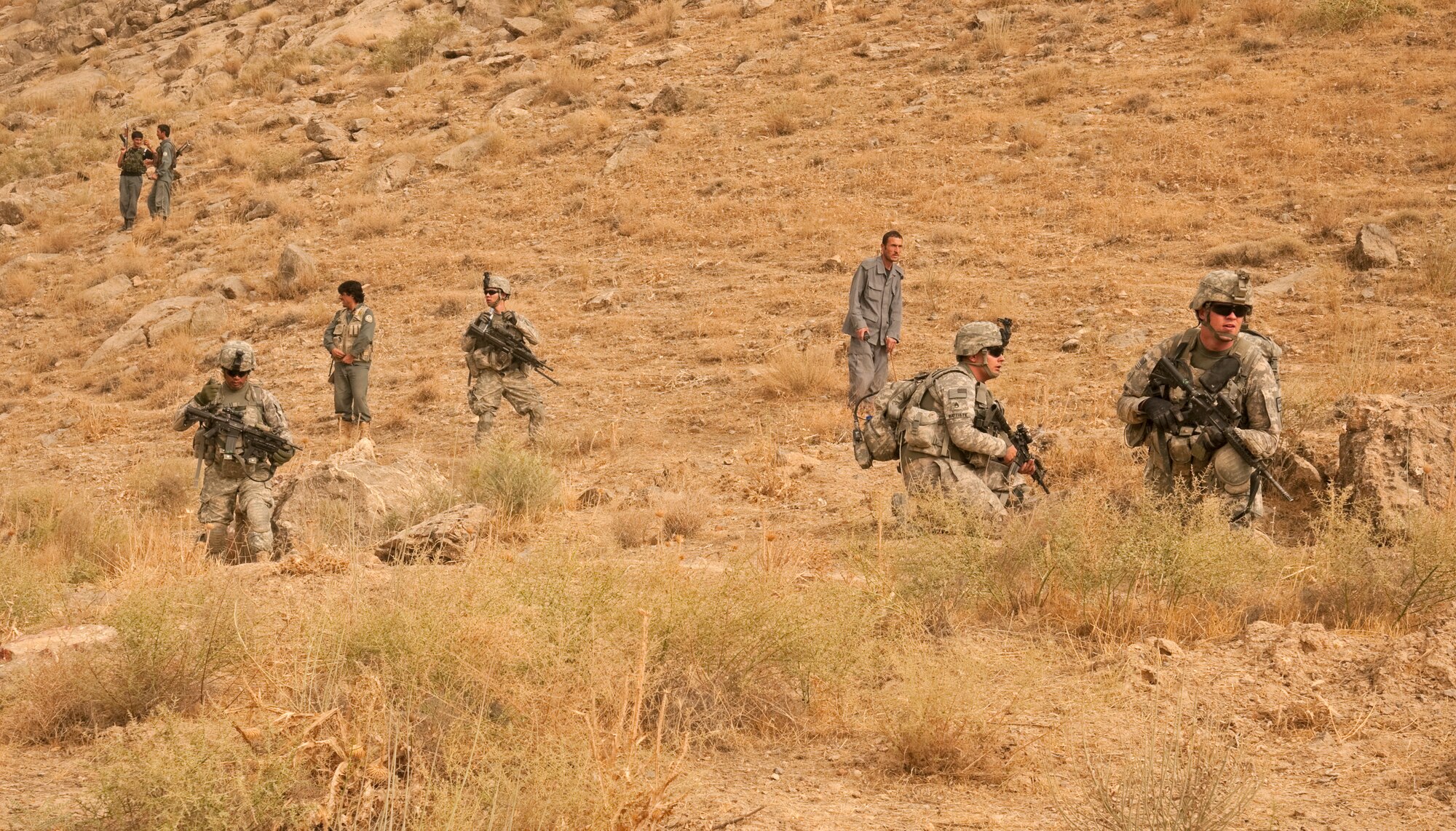 COMBAT OUTPOST MIZAN, Afghanistan - Soldiers assigned to 3rd Platoon, Fox Company, 2nd Squadron, 2nd Stryker Cavalry Regiment and Afghan National Police take a quick break during a dismounted patrol near Combat Outpost Mizan, Mizan District, Zabul province, Aug. 26. Members of 3rd Platoon, Provincial Reconstruction Team Zabul and Afghan National Security Forces patrolled the area to meet with local elders and ensure security in the area. (U.S. Air Force Photo/Senior Airman Nathanael Callon/Released)