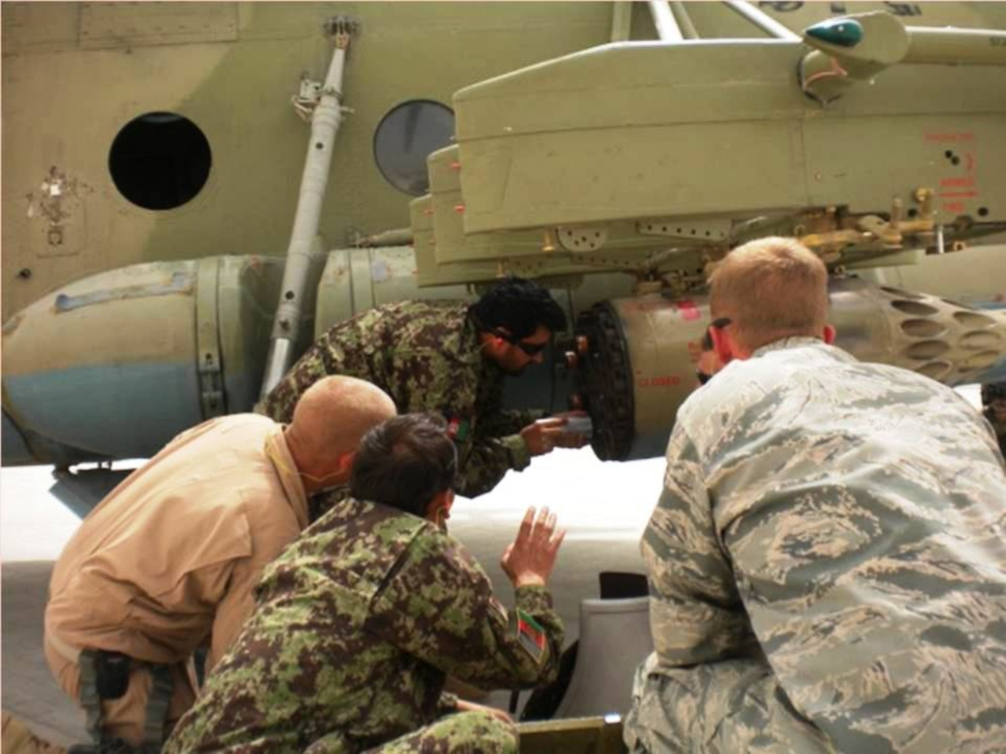 KANDAHAR, Afghanistan - Members of the Afghan Air Force and CAPTF load rockets on a Mi-17 helicopter during a training mission on Aug 27 & 28, 2010. (U.S. Military photo/RELEASED).