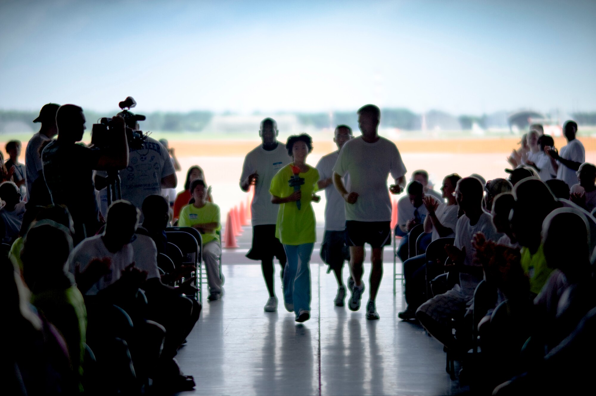 Rumiko Taneichi from Kadehashi-Ryo runs the Olympic torch into Hangar 949 with U.S. Air Force Col. Van Wimmer, 35th Fighter Wing vice commander, kicking off the annual Special Olympics at Misawa Air Base, Japan, Aug. 28, 2010. (U.S. Air Force photo by Staff Sgt. Samuel Morse/Released)