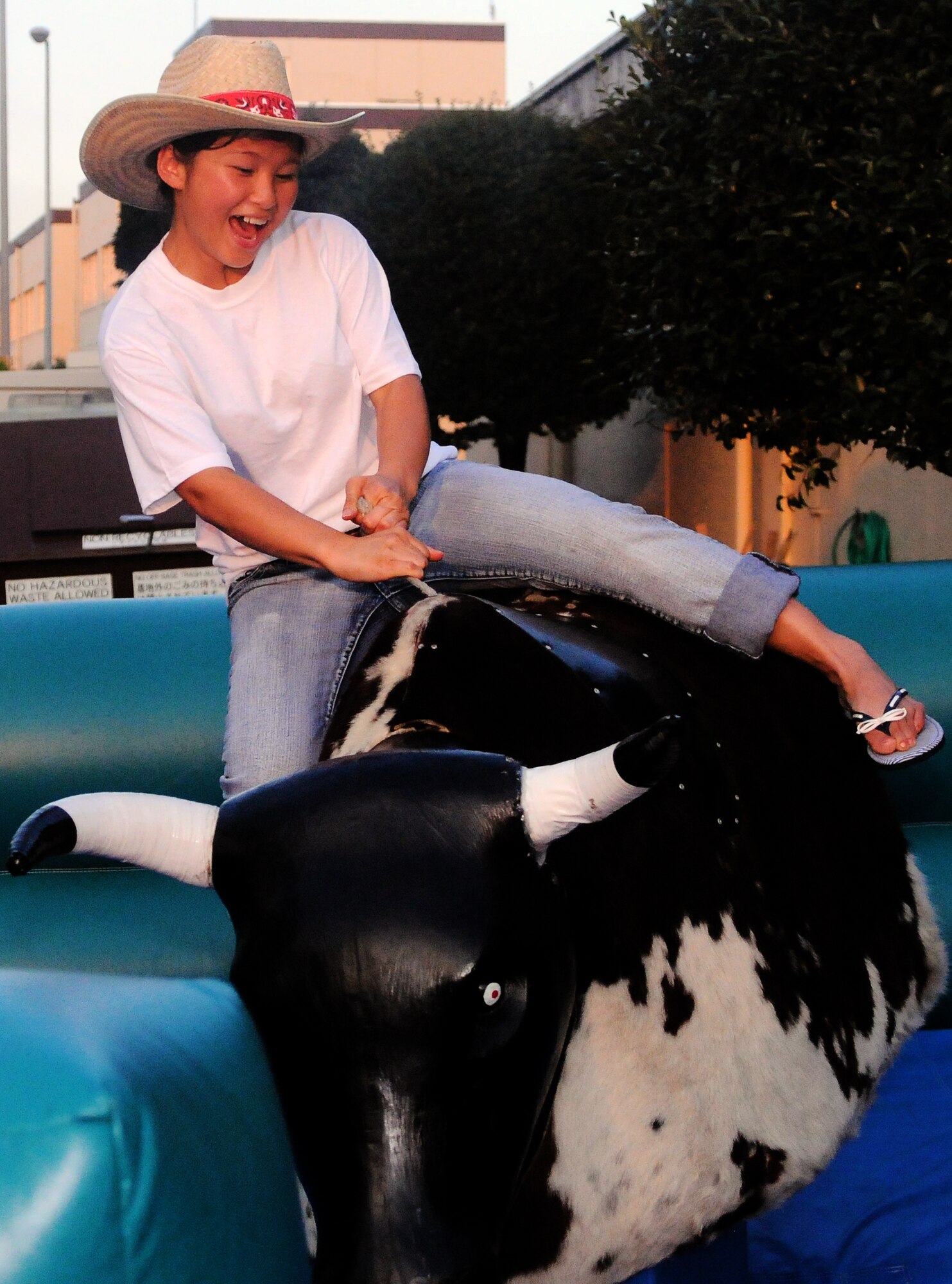 YOKOTA AIR BASE, Japan -- Airman 1st Class Yang Vang, 374th Force Support Squadron food services, enjoys a wild ride on a mechanical bull during the Cowboy Customer Appreciation dinner, here August 26. Airman Vang rode the bull for 25 seconds. (U.S. Air Force photo/Airman 1st Class Katrina R. Menchaca)