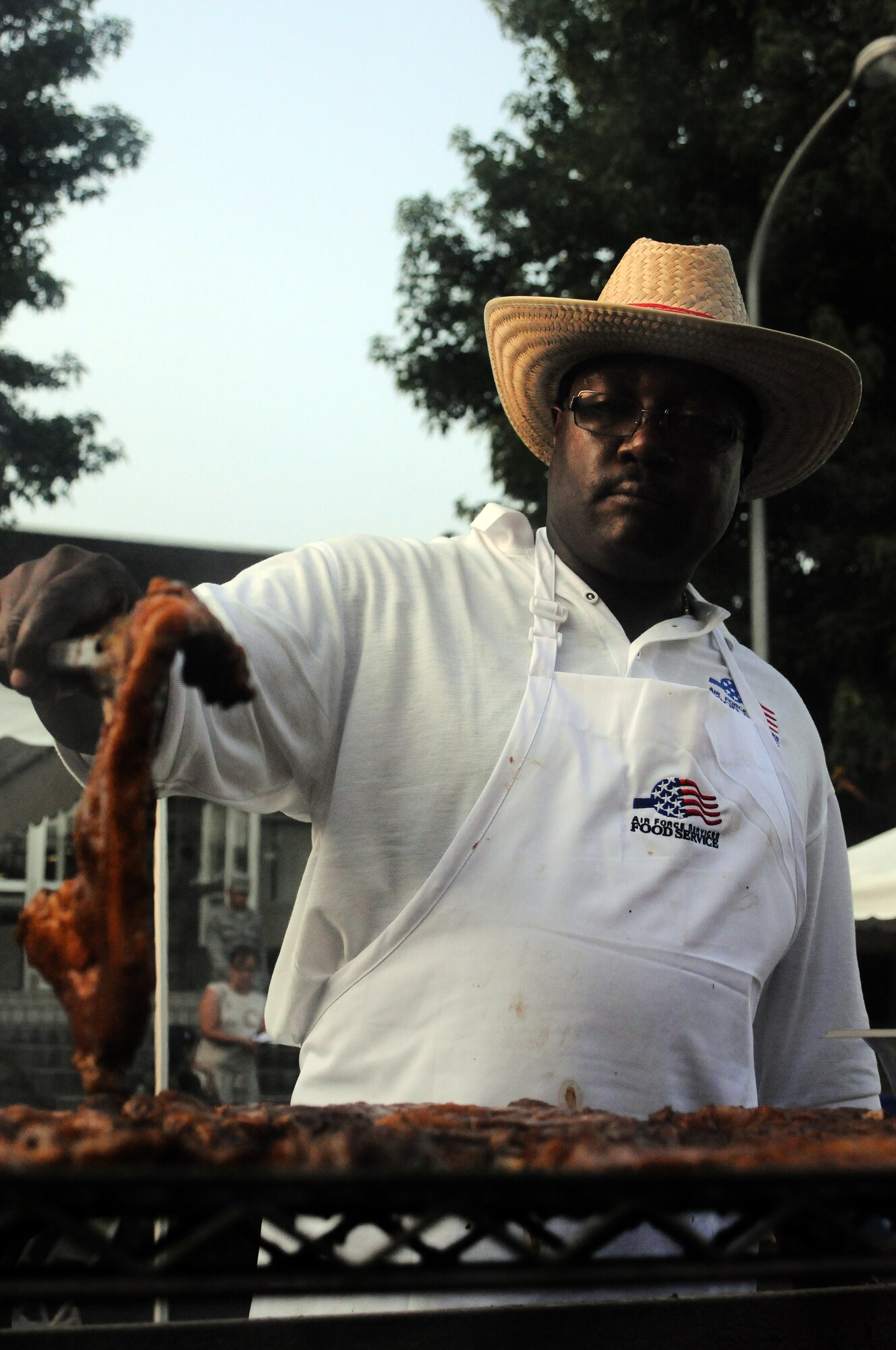 YOKOTA AIR BASE, Japan -- Tech. Sgt. Tyrone Bradley, 374th Force Support Squadron executive chief, prepares steak for a "surf and turf" Cowboy Customer Appreciation dinner, here August 26. The customer appreciation dinner was held outside the Samurai Cafe. (U.S. Air Force photo/Airman 1st Class Katrina R. Menchaca)