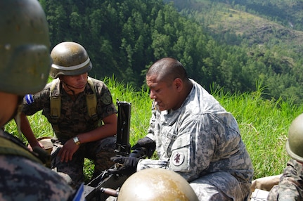 SOTO CANO AIR BASE, Honduras --  Spc. Salvador Nunez, a 1-228th Aviation Regiment Soldier, conducts a PMI on the M2 with Honduran soldiers at Zambrano Range here Aug. 25. Proper assembly, maintenance, preliminary marksmanship instruction and firing techniques were taught by bilingual 1-228th Soldiers providing Honduran Soldiers with a basic knowledge of both the M2 and M249 weapons systems. (Photo courtesy of Capt. Thomas Pierce)