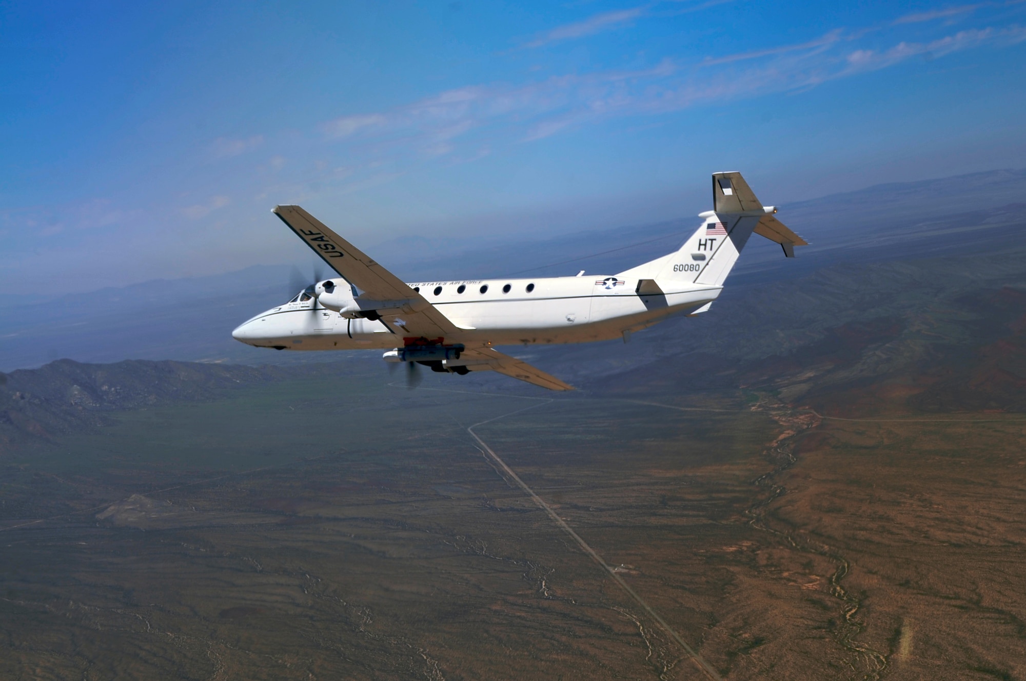 HOLLOMAN AIR FORCE BASE, N.M. -- A highly-modified Air Force C-12J with an inert Laser Maverick on the belly of its fuselage is flying after a testing mission Aug. 26, 2010. The Laser Maverick is an air-to-ground missile that can seek out laser-designated targets. This is the first time the 586th Flight Test Squadron has tested external stores on the modified C-12J, which is normally a “people mover”. (U.S. Air Force photo by Airman 1st Class Joshua Turner / Released)