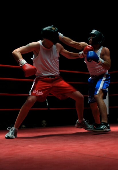 HOLLOMAN AIR FORCE BASE, N.M -- Albert Dominguez (blue shorts), 49th Force Support Squadron, lands a straight punch on John Buckley (red shorts), 49th Civil Engineer Squadron, during the fifth Raptor Rumble at the Domenici Fitness and Sports Center Aug. 27, 2010. The referee stopped the fight giving Dominguez a victory over Buckley. (U.S. Air Force photo by Airman 1st Class Joshua Turner / Released)