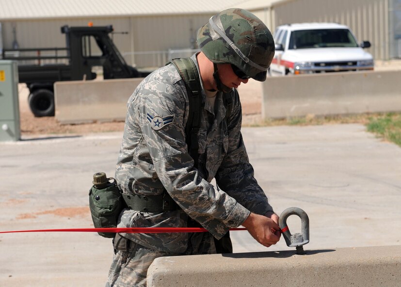 DYESS AIR FORCE BASE, Texas—Airman 1st Class Max Morell, 7th Civil Engineer Squadron, cordons off an area after finding an unexploded ordinance Aug. 30 here. Operational Readiness Exercises occur every couple of months to ensure Airmen are mission ready. (U.S. Air Force photo/ Senior Airman Felicia Juenke)               