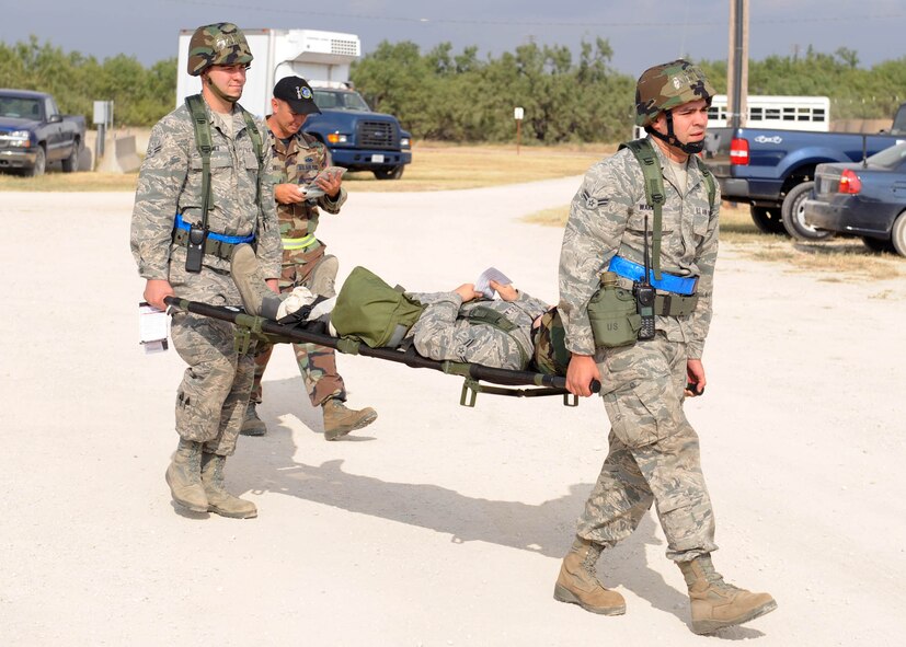 DYESS AIR FORCE BASE, Texas—Airman 1st Class Christopher Gomez and Airman 1st Class Brian Warman, both from 7th Expeditionary Communication Squadron, simulate a 2 -person litter carry Aug. 30 here. Operational Readiness Exercises occur every couple months to ensure Airmen are mission ready. (U.S. Air Force photo/ Senior Airman Felicia Juenke)