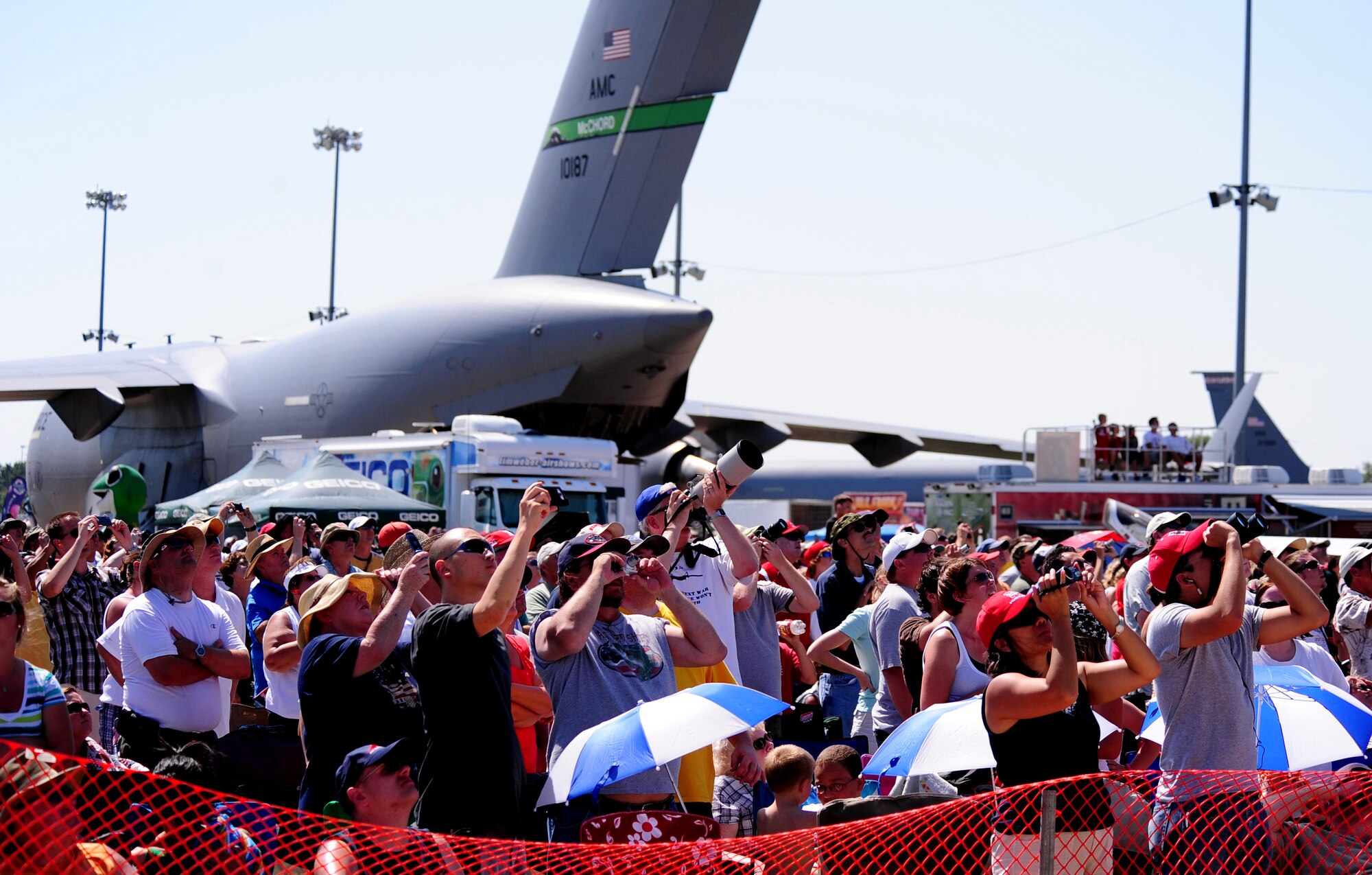 OFFUTT AIR FORCE BASE, Neb. - Binoculars, cell phone cameras and zoom lenses prepare to capture the F-22 Raptor as it performs over the skies of Offutt for the first time as part of the 2010 Defenders of Freedom Open House and Air Show. The show included aerial demonstrations by the F-22 Raptor as well as the U.S. Air Force Thunderbirds among others.  U.S. Air Force photo by Josh Plueger
