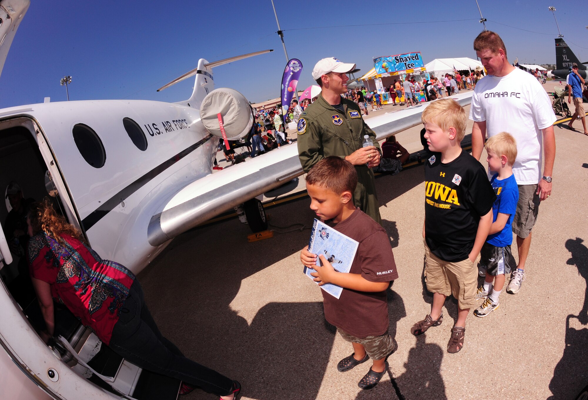OFFUTT AIR FORCE BASE, Neb. - Families wait in line to get an inside look at a T-1A Jayhawk static display at the 2010 Defenders of Freedom Open House and Air Show, Aug. 28.  The show provided the local community with a rare chance to see modern and historic aircraft up close and to meet military members. U.S. Air Force photo by Josh Plueger
