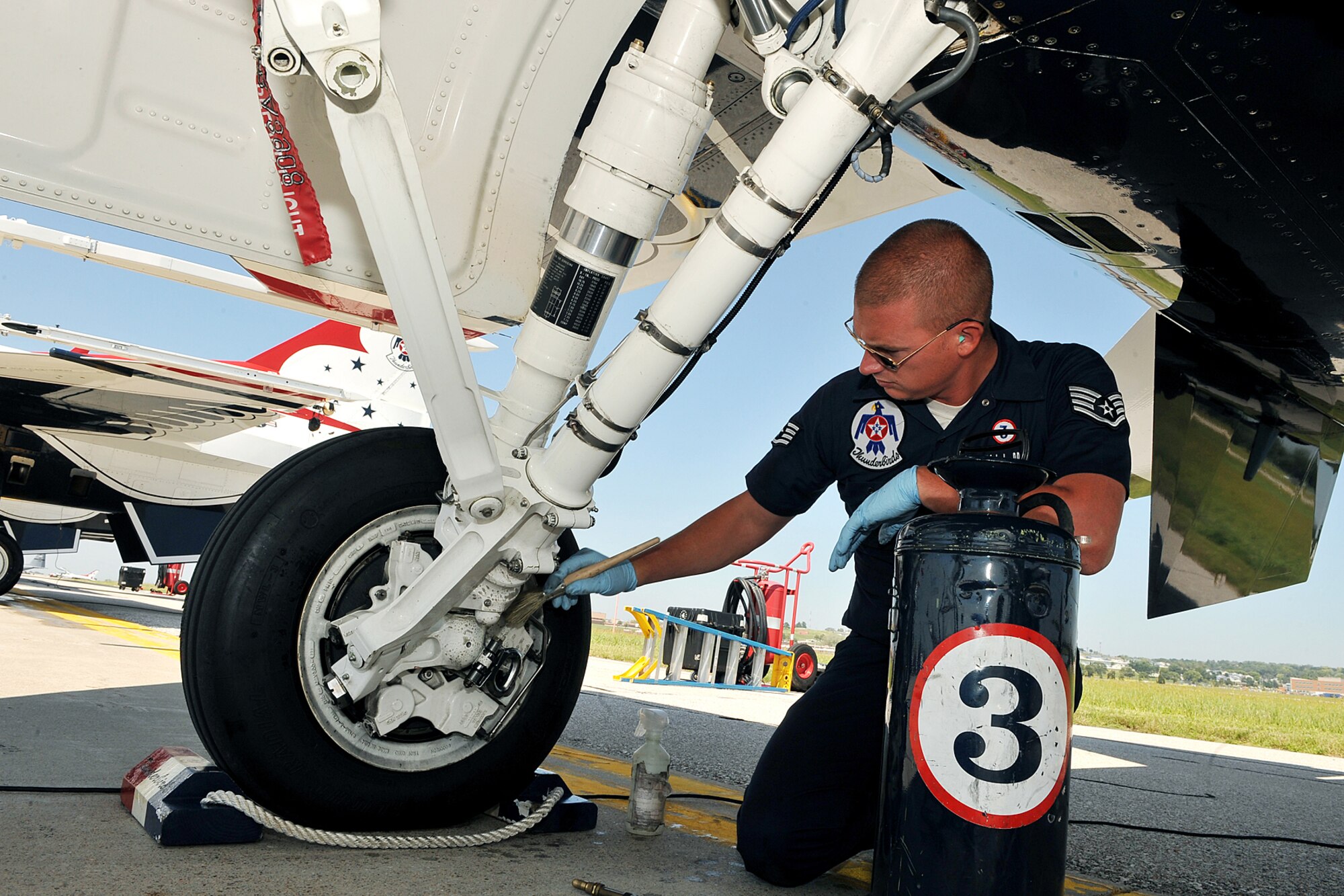 OFFUTT AIR FORCE BASE, Neb. - Staff Sgt. Jonathan Mitchell, crew chief with the U.S. Air Force Thunderbirds, dusts off the brake assembly on an F-16 before take-off during the 2010 Defenders of Freedom Open House and Air Show here Aug. 28. Guests were treated to numerous static aircraft displays, ground shows and aerial demonstrations during the two-day show. U.S. Air Force photo by Charles Haymond. 