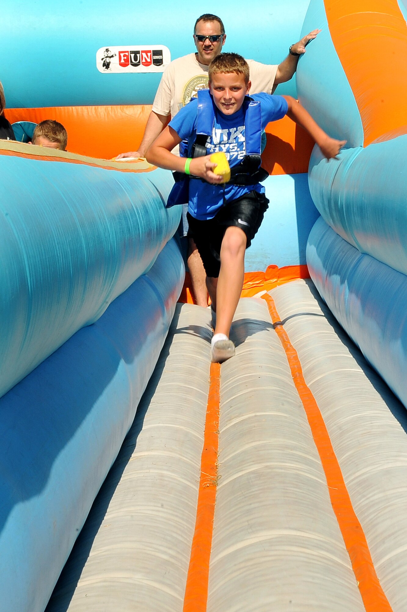 OFFUTT AIR FORCE BASE, Neb. - Jack Charleston, the son of retired Navy veteran Mark Charleston, runs on an inflatable bungee run during the 2010 Defenders of Freedom Open House and Air Show here Aug 28. Guests were treated to numerous static aircraft displays, ground shows and aerial demonstrations during the two-day show. U.S. Air Force photo by Charles Haymond