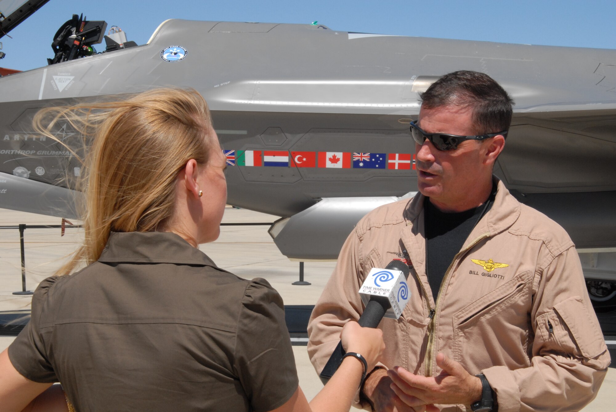 Bill Gigliotti, Lockheed Martin test pilot, talks with a local Time Warner Channel 3 reporter during a media event Aug. 27.  The event showcased the developmental test and evaluation of the Joint Strike Fighter. (Air Force photo by Stephen K. Robinson)