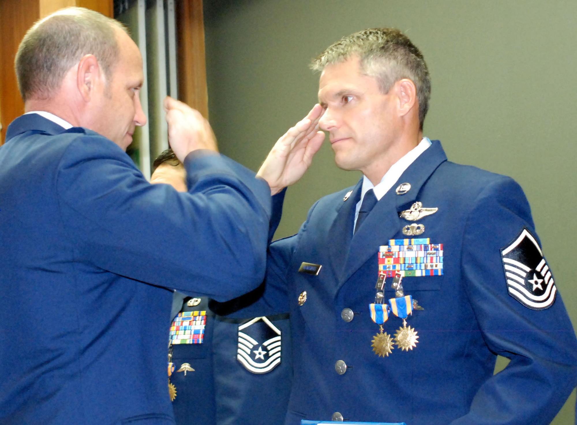 Lt. Col. Kurt Matthews (left), 308th Rescue Squadron commander, salutes Master Sgt.  Jeffrey McManus after presenting him his second of three medals on Aug. 8, 2010, at Patrick Air Force Base, Fla. Sergeant McManus was awarded two Air Medals and an Air Force Commendation Medal with valor. An Air Force Reserve pararescuemen with the 920th Rescue Wing, Sergeant McManus received his awards for his exceptional service helping to rescue and evacuate survivors of 36 avalanches in Salang Pass in Afghanistan in February. (U.S. Air Force photo/Staff Sgt. Ken Salgat)