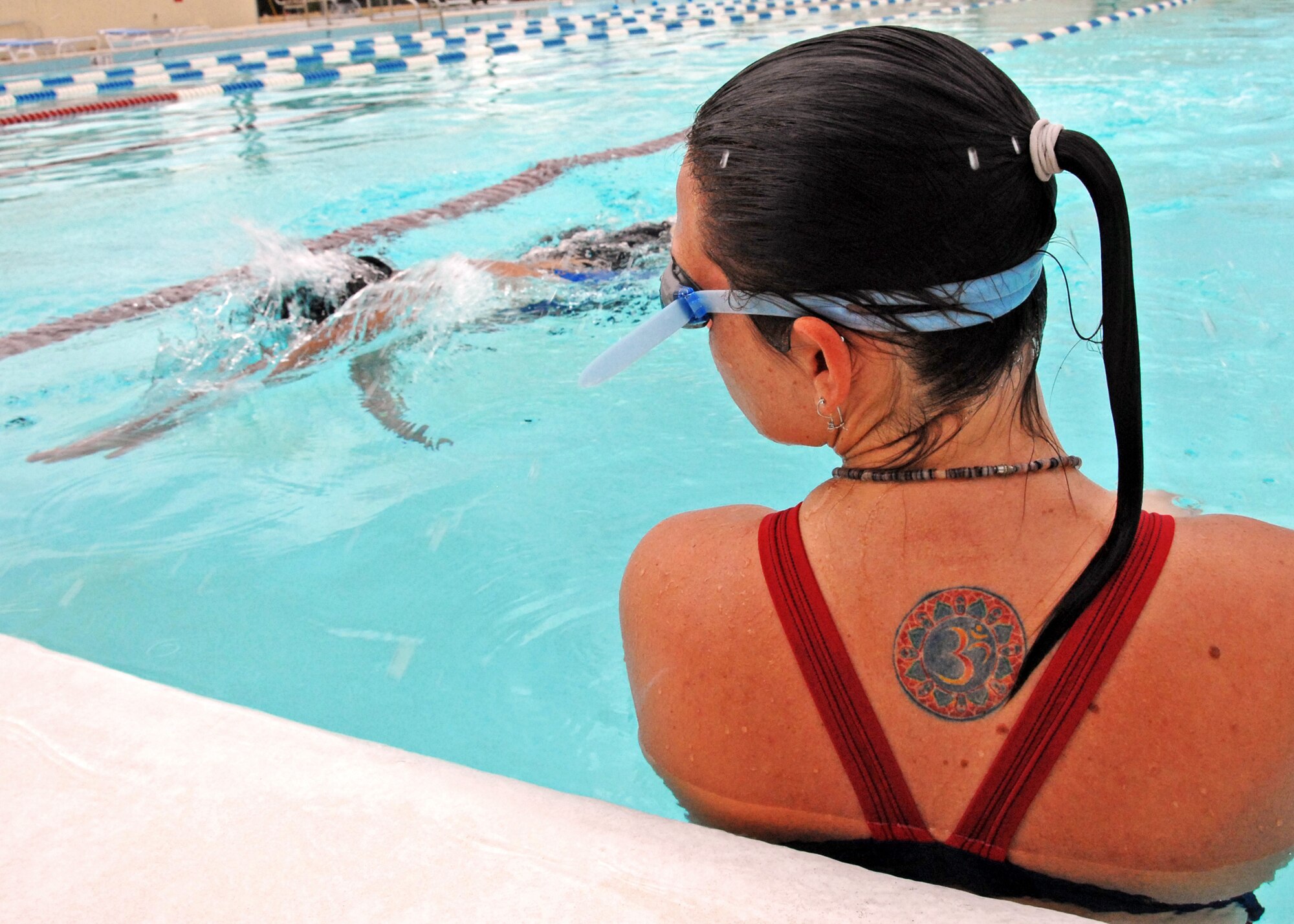 Melissa Young waits for her 46th Test Wing teammate to touch the wall before swimming her leg of the freestyle relay during the first-ever Water Olympics at Eglin Air Force Base, Fla., Aug. 27.  Teams from three different wings competed in three separate team-swimming relays.  The 53rd team dominated the event winning all three relays with ease.  A team from 46th Test Wing also competed.  (U.S. Air Force photo/Samuel King Jr.)