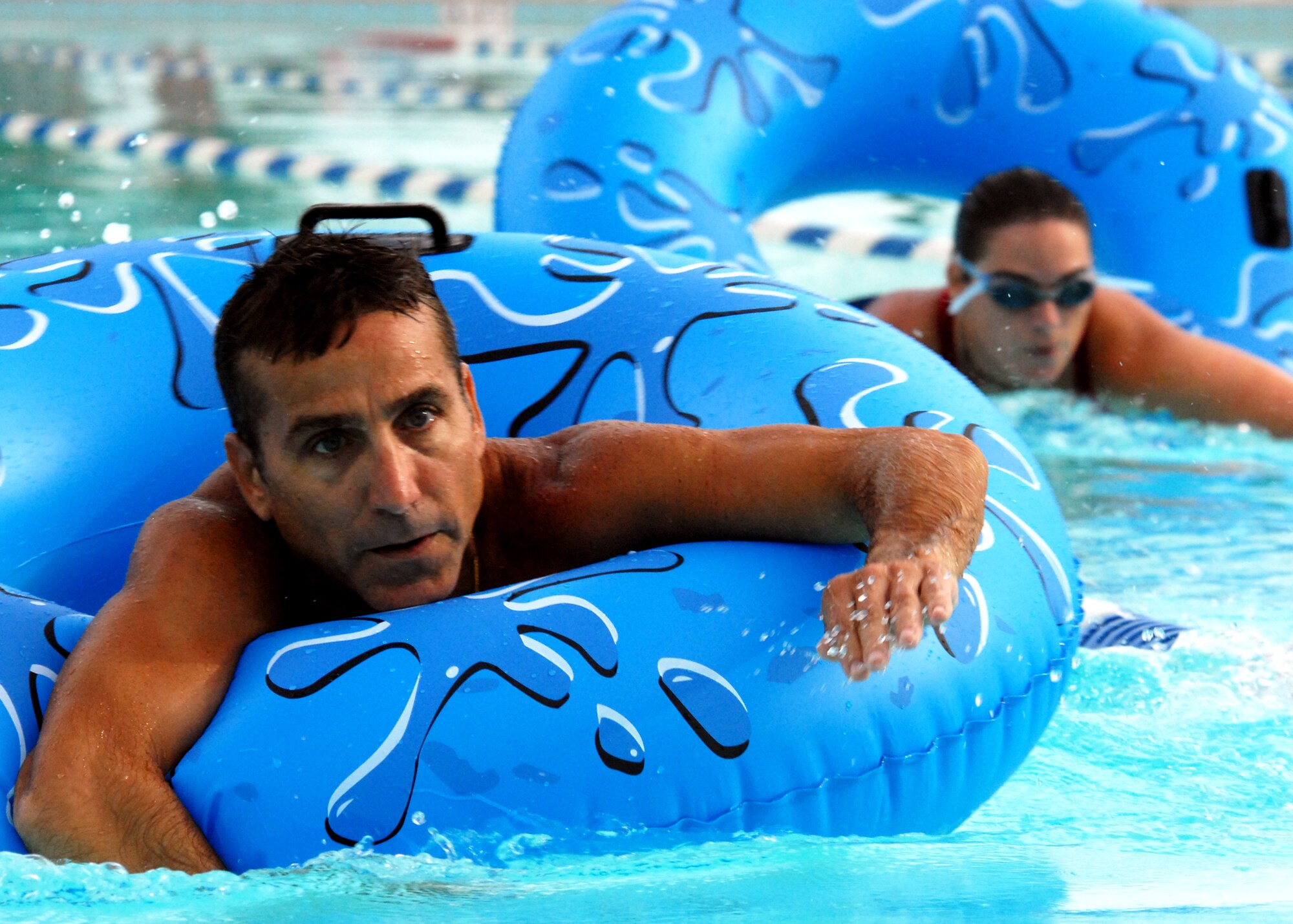Todd Staats, 96th Air Base Wing, leads the way in the floatation relay during the first-ever Water Olympics at Eglin Air Force Base, Fla., Aug. 27.  Teams from three different wings competed in three separate team-swimming relays.  The 53rd team dominated the event winning all three relays with ease.  A team from 46th Test Wing also competed.  (U.S. Air Force photo/Samuel King Jr.)