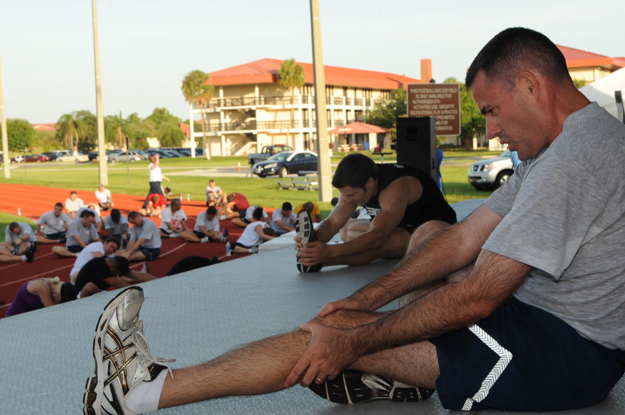 Col. Lenny J. Richoux, Commander, 6th Air Mobility Wing, participates in cool down stretching with special guest Tony Horton, creator of workout program P90X at MacDill Air Force Base, Fla., Aug. 30, 2010.  Tony Horton conducted a free strength training workout for Team MacDill participants on the Short Fitness and Sports Center Ball Fields. (US Air Force photo by Tech Sgt. Tanika Belfield /Released)