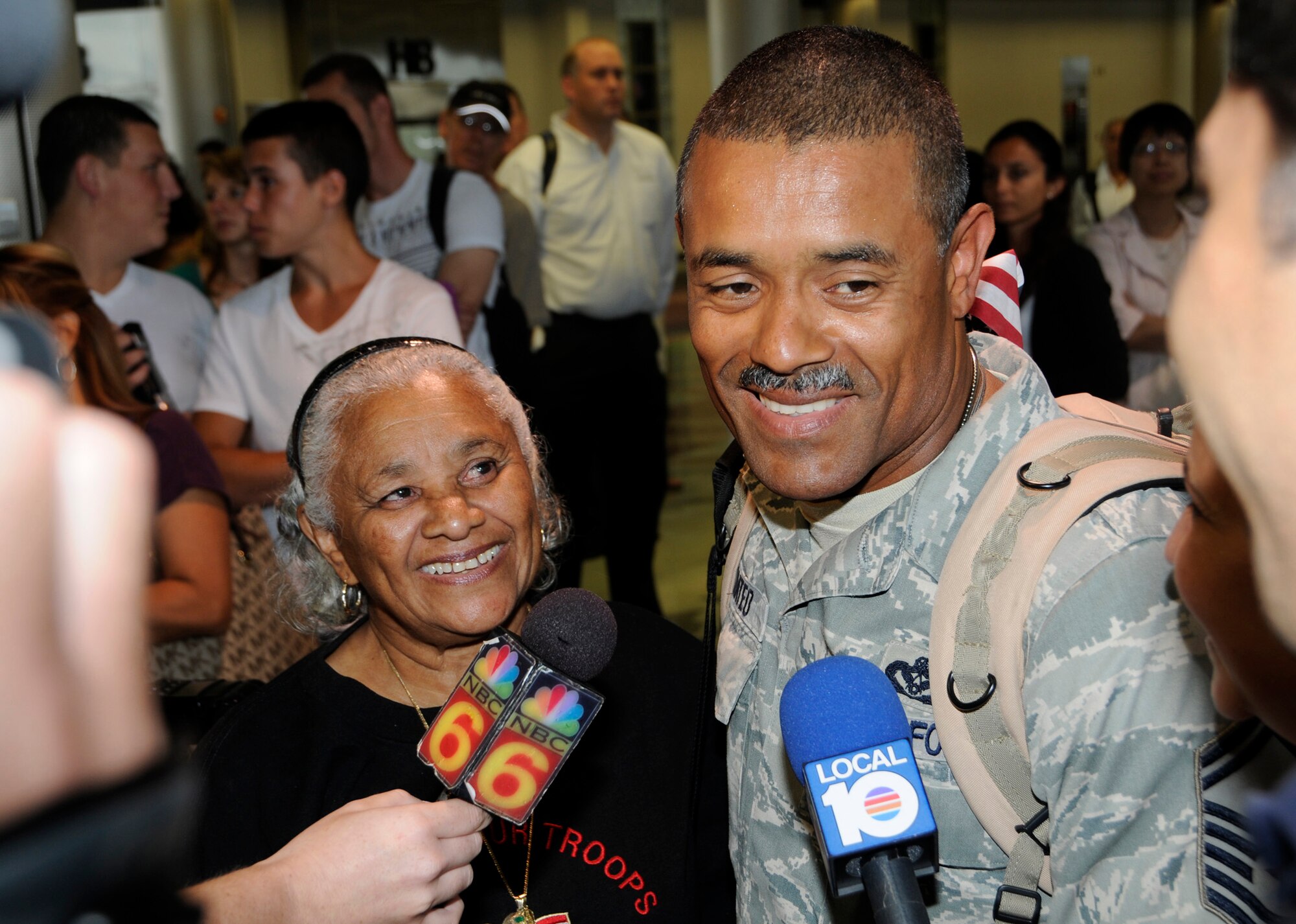 Senior Master Sgt  Luis Mateo, 48nd Fighter Wing Civil Engineer, along with his mother and wife, speak with media upon his return home from Iraq Aug 27. Thirteen Airmen from Homestead Air Reserve base arrived Aug 27 and seven returned Aug 28 The Airmen spent six months deployed to Kirkuk Air Base, Iraq working as road builders and light construction engineers. (U.S. Air Force photo by Senior Airman Lou Burton) 
