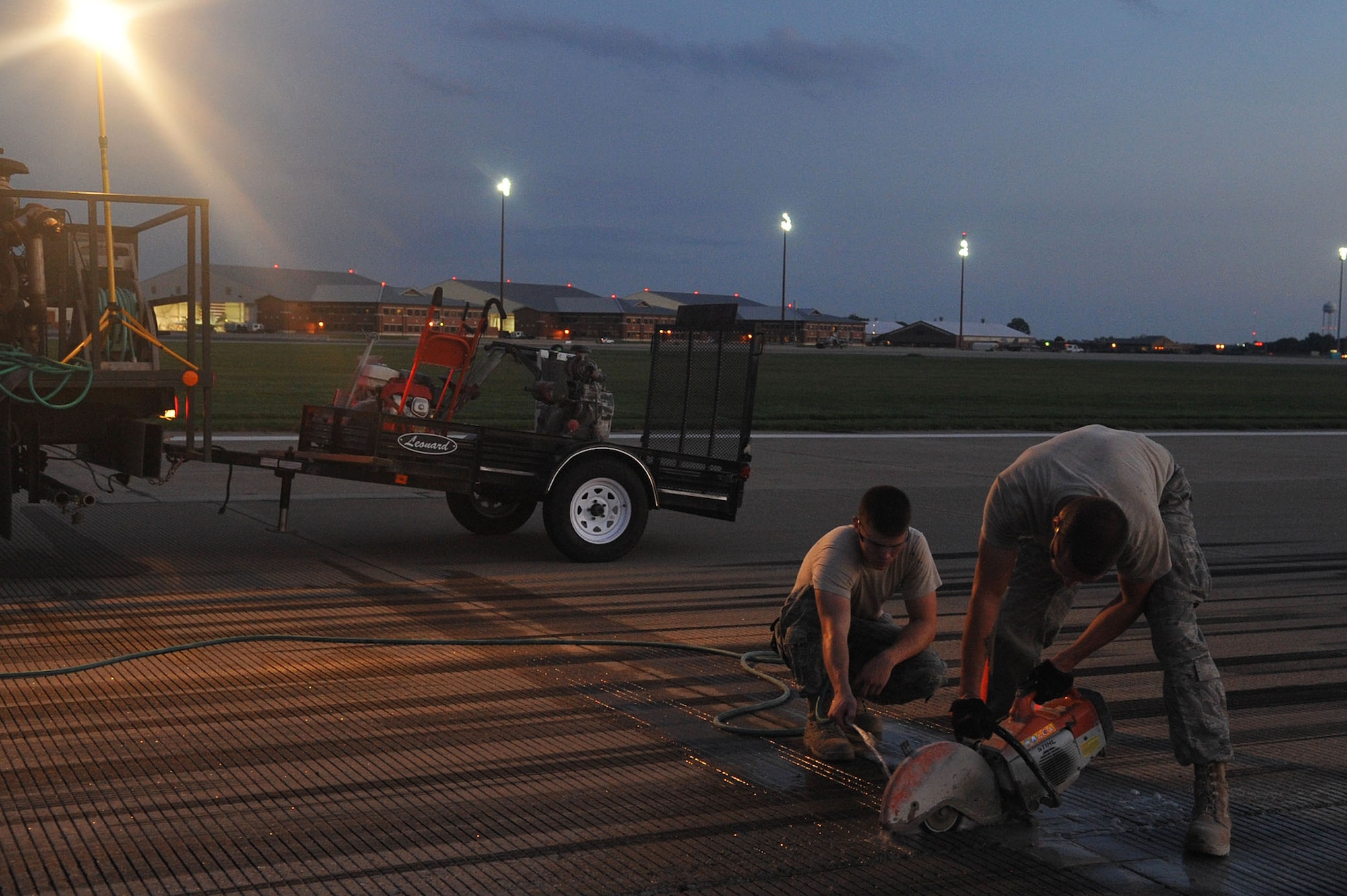 LANGLEY AIR FORCE BASE, Va – Two 633d Civil Engineer Squadron pavements and equipment apprentices, saw a portion of the runway Aug. 25. With the help of the 633d Civil Engineer Squadron and private contractors, the 1st Operations Support Squadron was able to overhaul the runway in just 10 days. (U.S. Air Force photo/Staff Sgt. Ashley Hawkins)(RELEASED)