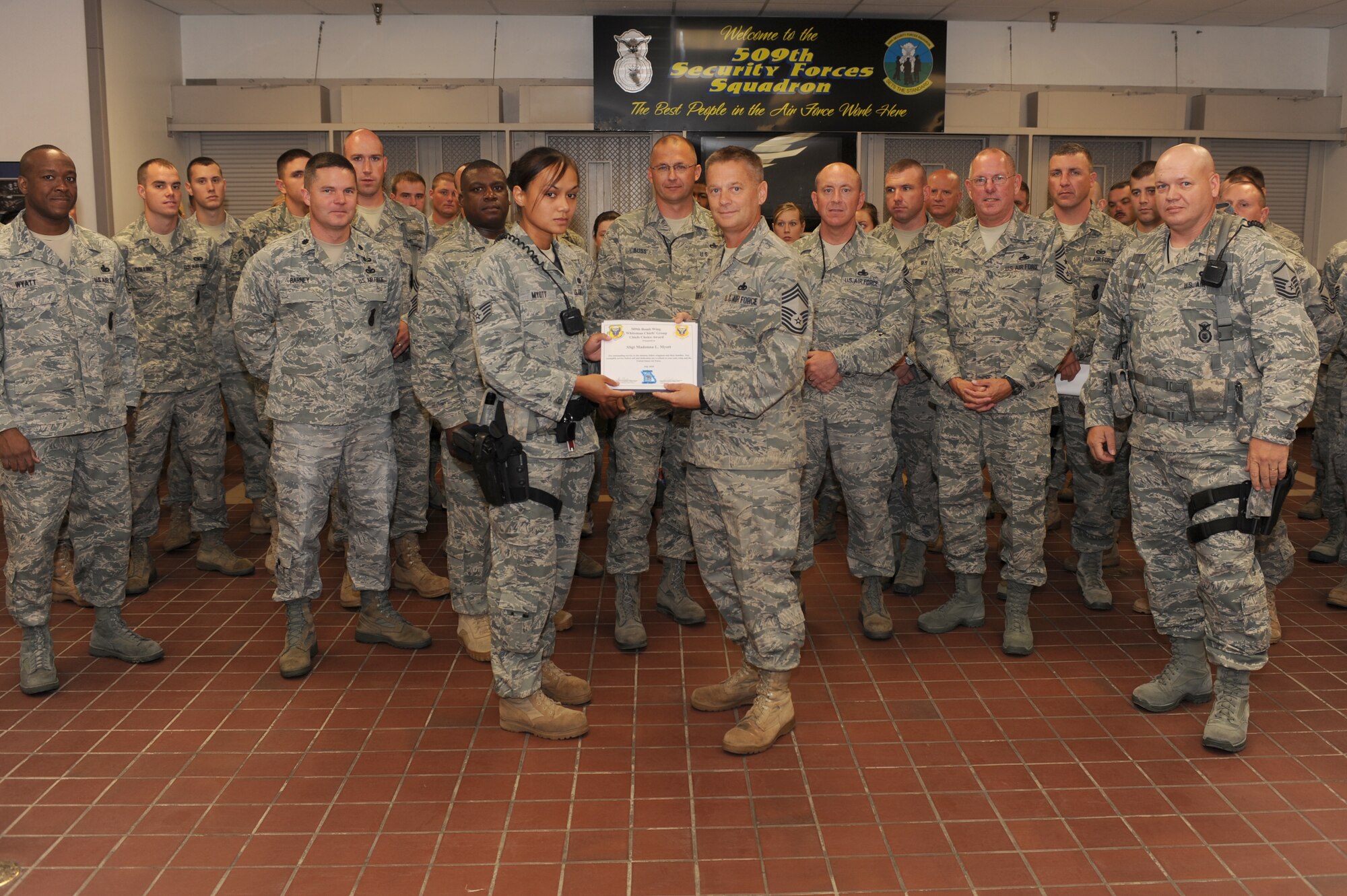WHITEMAN AIR FORCE BASE, Mo- Staff Sgt. Madonna Myott, 509th Security Forces Squadron, law enforcement, receives the July Chiefs Choice Award here, Aug. 27. Sergeant Myott received the award for her actions, during exercises and daily tasks, including her first response to a heat stroke victim and saving his or her life.  The Chiefs Choice Award highlights Whiteman's finest Airmen for extraordinary efforts on the job. (U.S. Air Force photo by Senior Airman Carlin Leslie) 