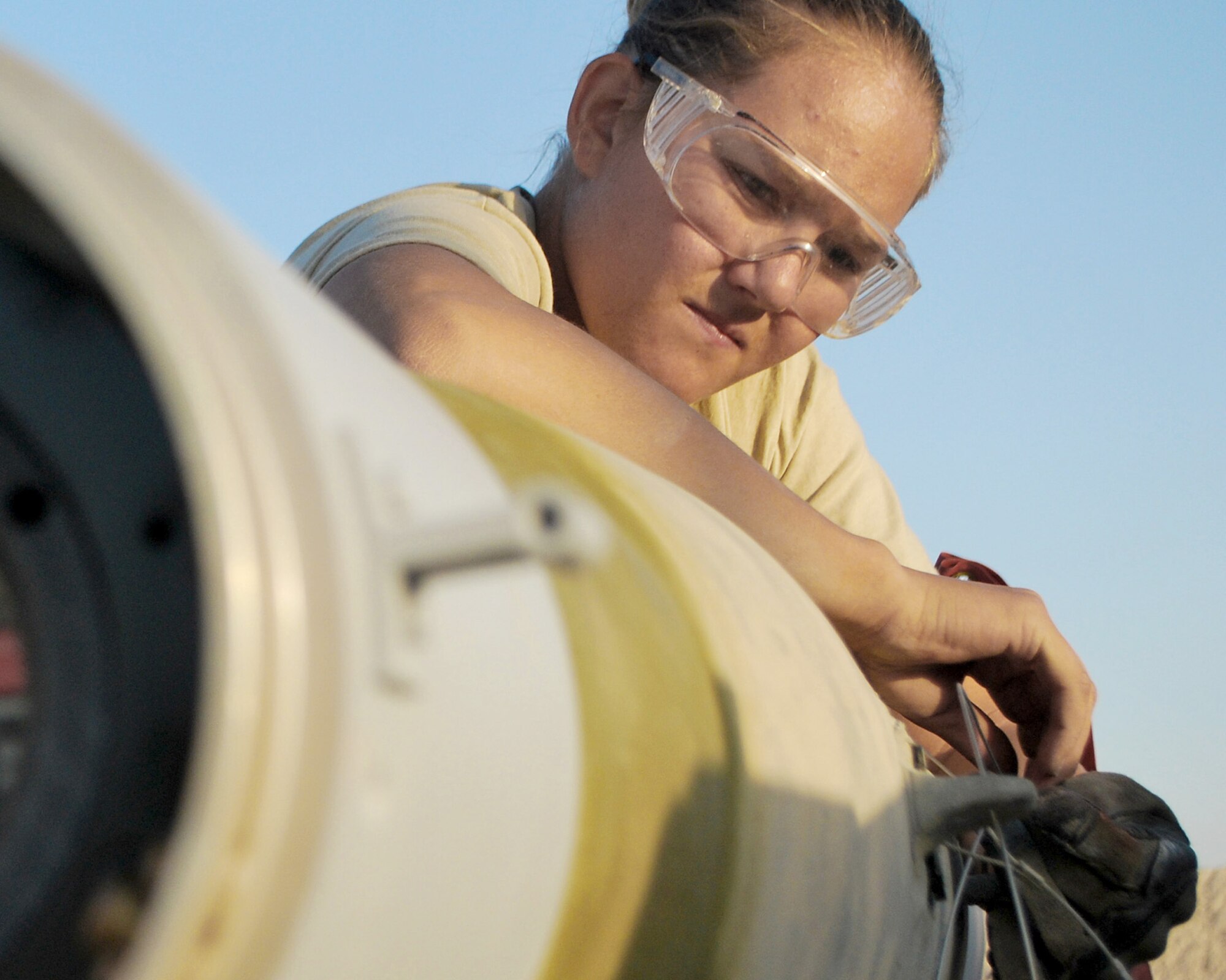 Senior Airman Melissa Bissinger fastens the arming wire on a bomb Aug. 23, 2010, at Kandahar Airfield, Afghanistan. Airman Bissinger is a munitions systems specialist with the 451st Expeditionary Maintenance Squadron Munitions Flight. (U.S. Air Force photo/Senior Airman Melissa B. White)