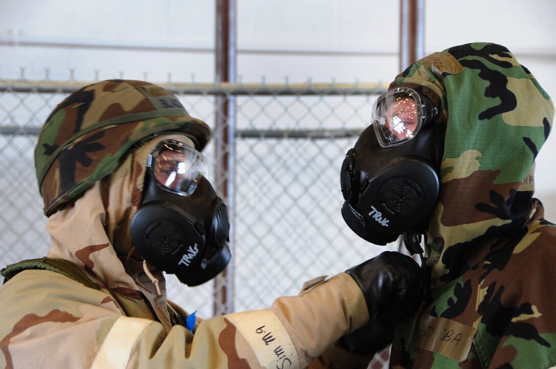 ELLSWORTH AIR FORCE BASE, S.D. -- (Left to right) Senior Airman Hugh
Blacketor, 28th Civil Engineer Squadron heating, ventilation and
air-conditioning journeyman, begins removing simulated contaminated mission oriented protective posture gear from Airman 1st Class Michael Mays, 28 CES structural apprentice, during a phase II operational readiness exercise, Aug. 24.  The MOPP gear is designed to protect Airmen from a chemical attack. (U.S. Air Force photo/Airman 1st Class Anthony Sanchelli)
