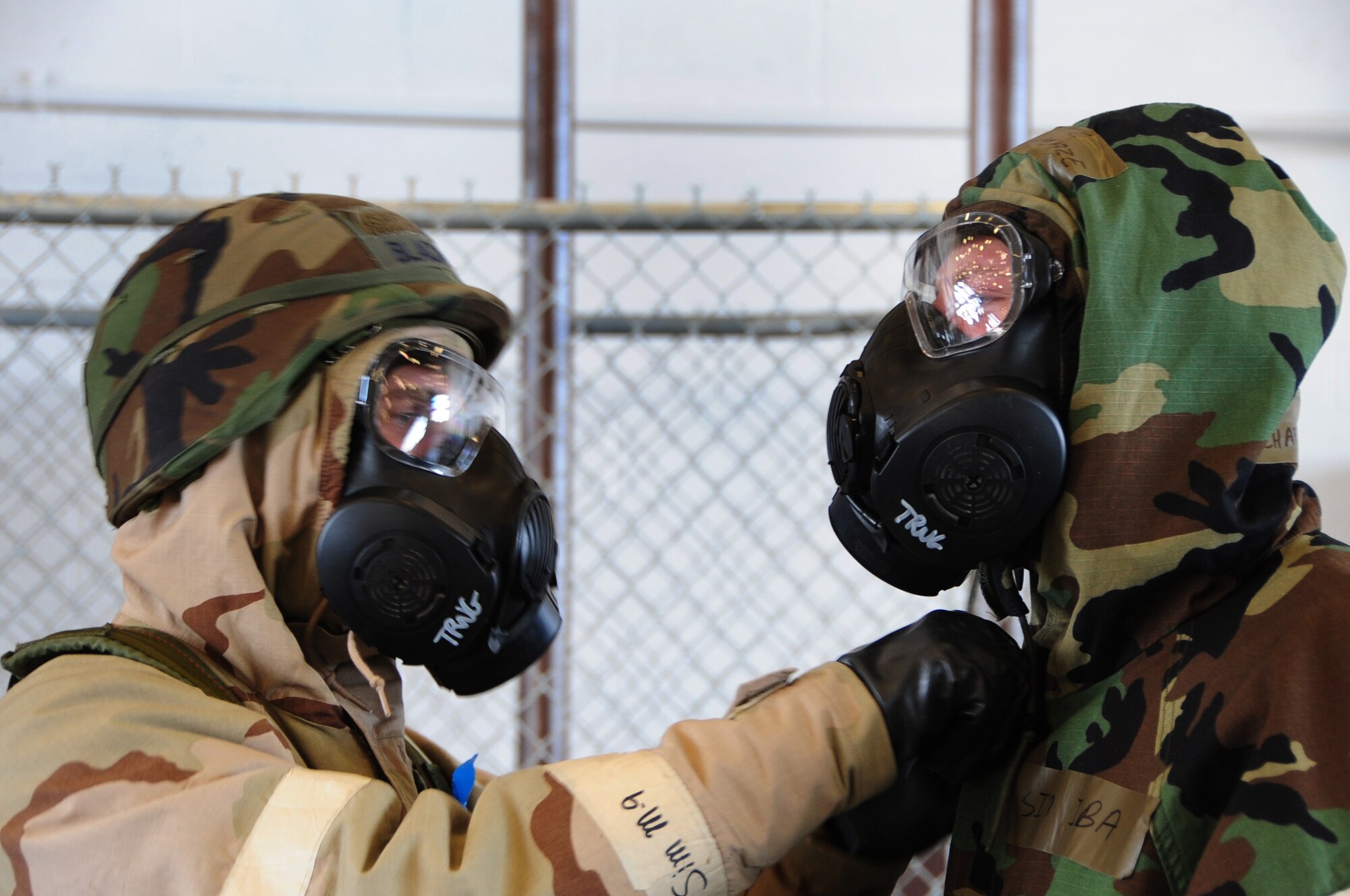 ELLSWORTH AIR FORCE BASE, S.D. -- (Left to right) Senior Airman Hugh
Blacketor, 28th Civil Engineer Squadron heating, ventilation and
air-conditioning journeyman, begins removing simulated contaminated mission oriented protective posture gear from Airman 1st Class Michael Mays, 28 CES structural apprentice, during a phase II operational readiness exercise, Aug. 24.  The MOPP gear is designed to protect Airmen from a chemical attack. (U.S. Air Force photo/Airman 1st Class Anthony Sanchelli)
