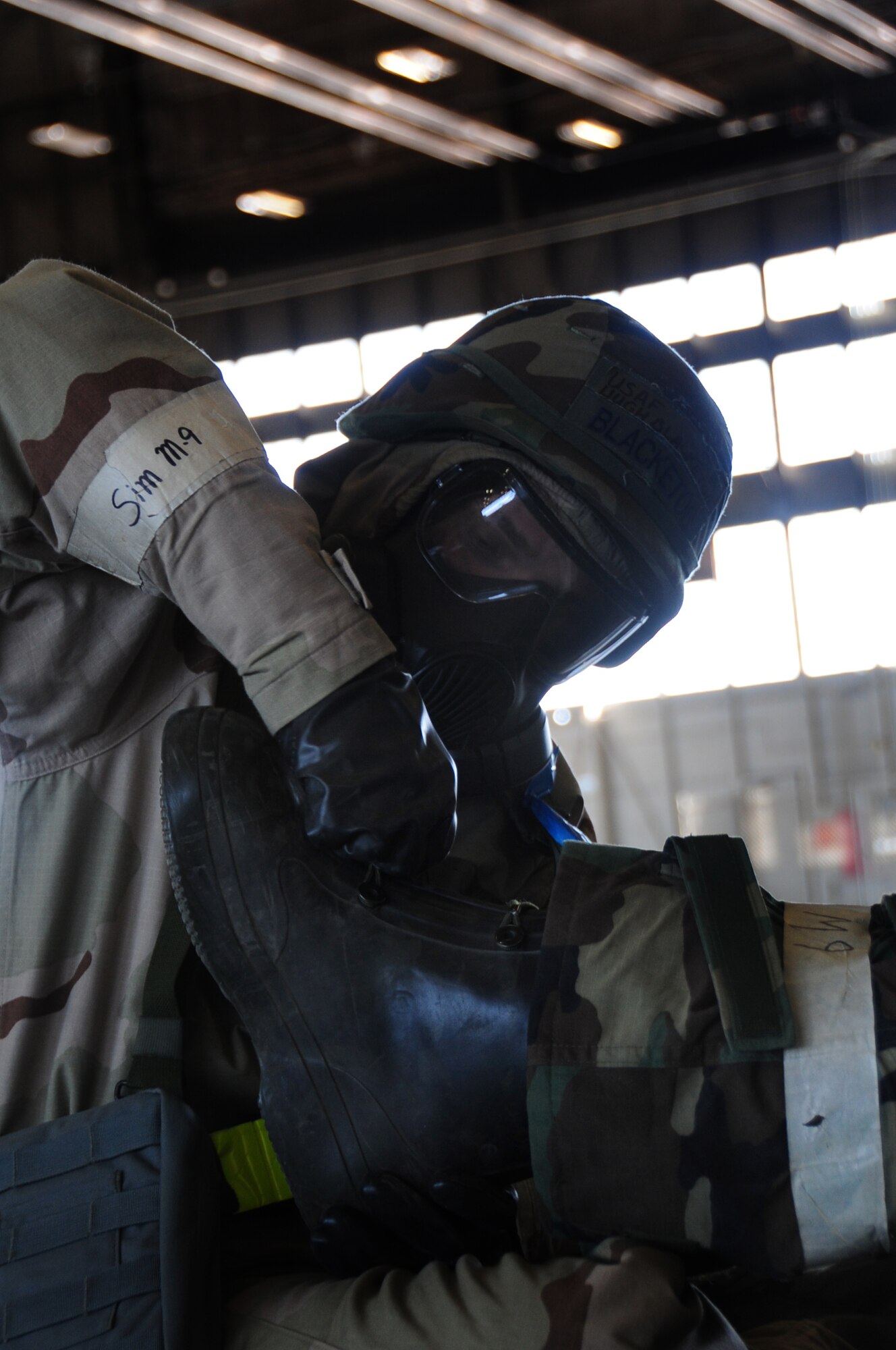 ELLSWORTH AIR FORCE BASE, S.D. -- Senior Airman Hugh Blacketor, 28th Civil Engineer Squadron heating, ventilation and air-conditioning journeyman, removes a simulated contaminated boot from Airman 1st Class Michael Mays, 28 CES structural
apprentice, during a phase II operational readiness exercise, Aug. 24.  The exercise is designed to train Airmen on situations that could occur during a real deployment. (U.S. Air Force photo/Airman 1st Class Anthony Sanchelli)

