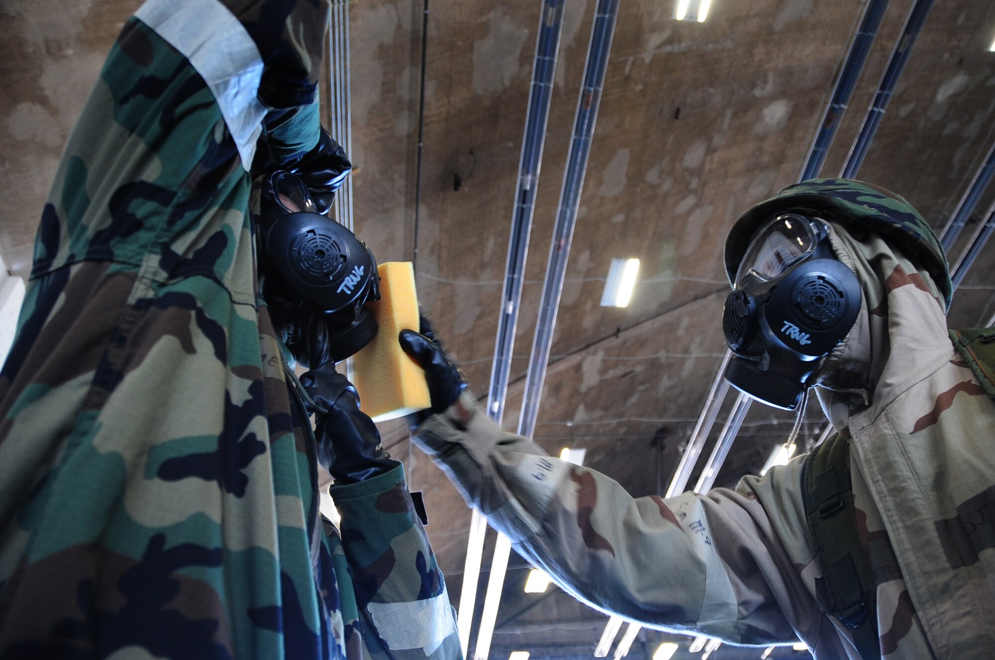 ELLSWORTH AIR FORCE BASE, S.D. -- (Right to left) Senior Airman Hugh
Blacketor, 28th Civil Engineer Squadron heating, ventilation and
air-conditioning journeyman, simulates decontaminating Airman 1st Class Michael Mays, 28 CES structural apprentice, during a phase II operational readiness exercise, Aug. 24.  The exercise tests Airmen and their abilities to operate in a simulated deployed environment. (U.S. Air Force photo/Airman 1st Class Anthony Sanchelli)
